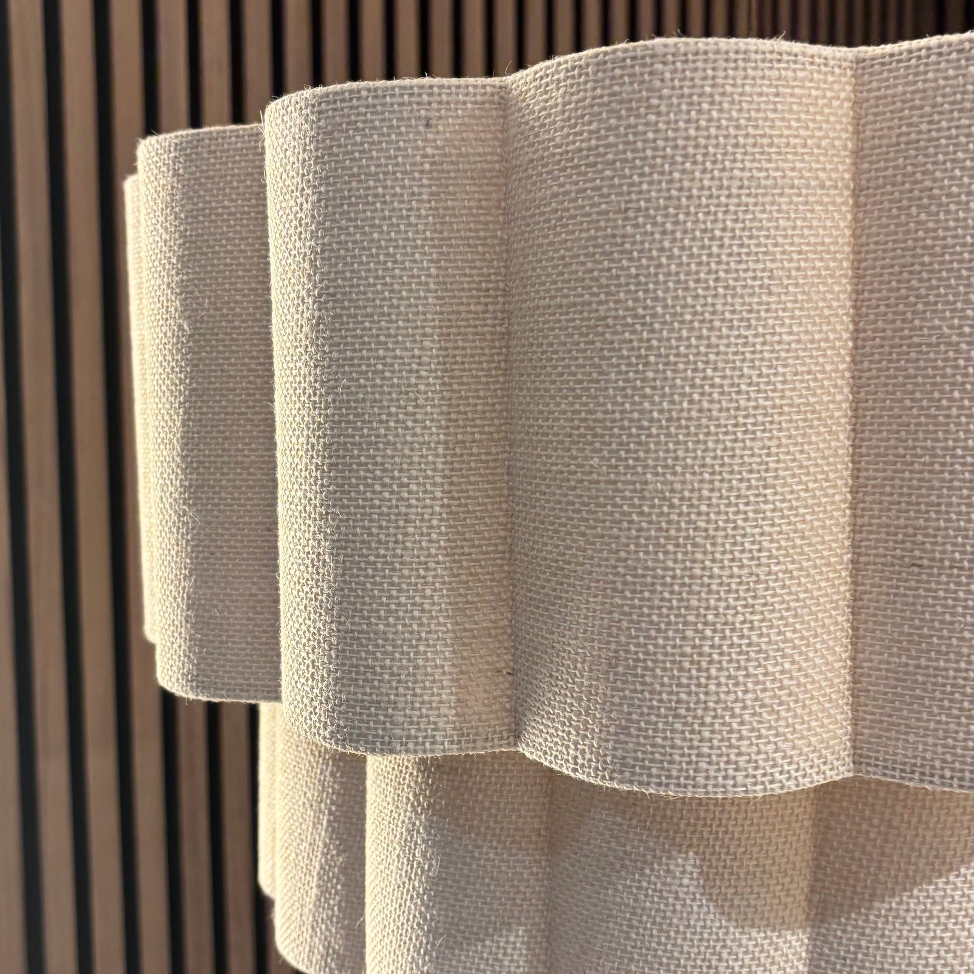 Textured white lampshade against a wooden panel background