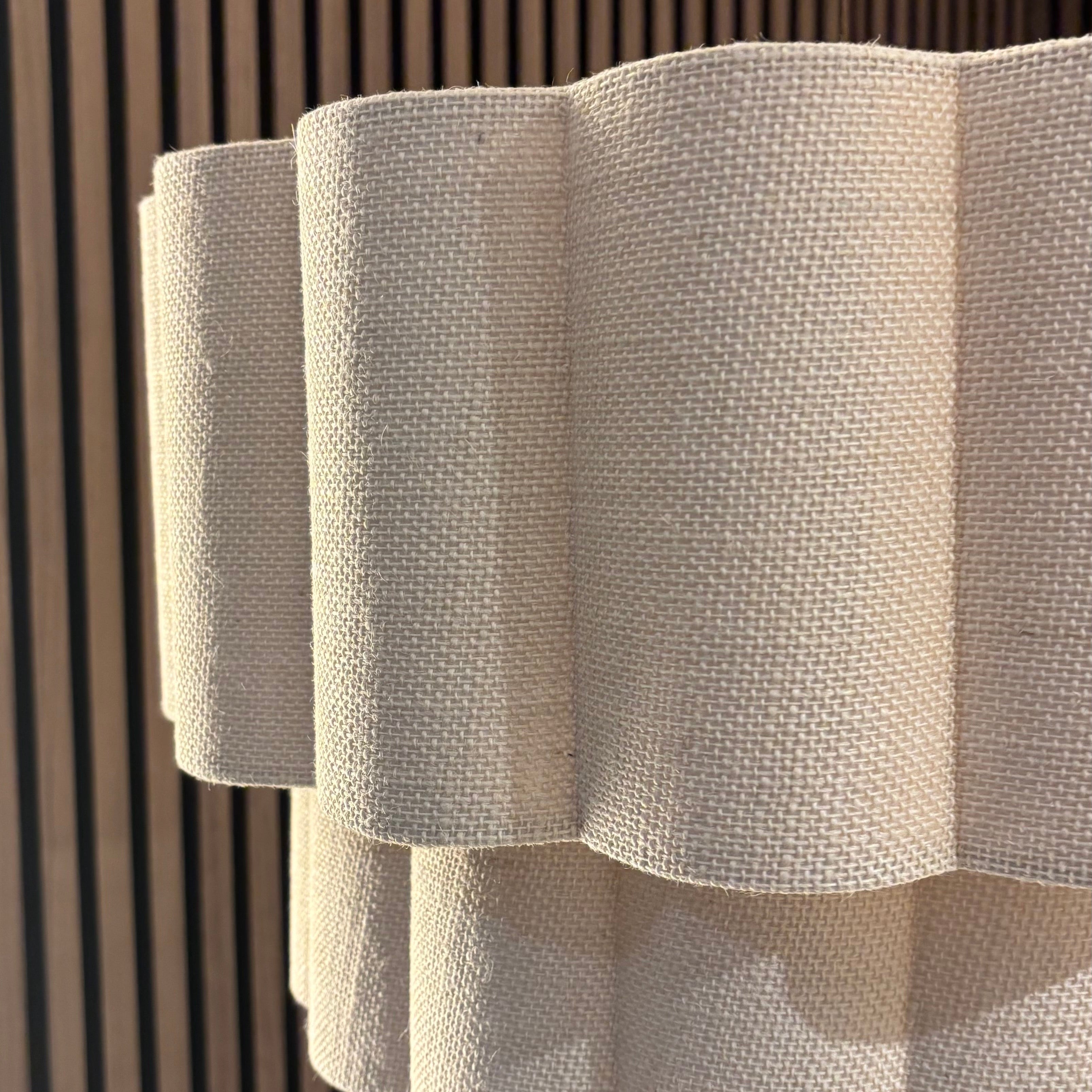 Textured white lampshade against a wooden panel background