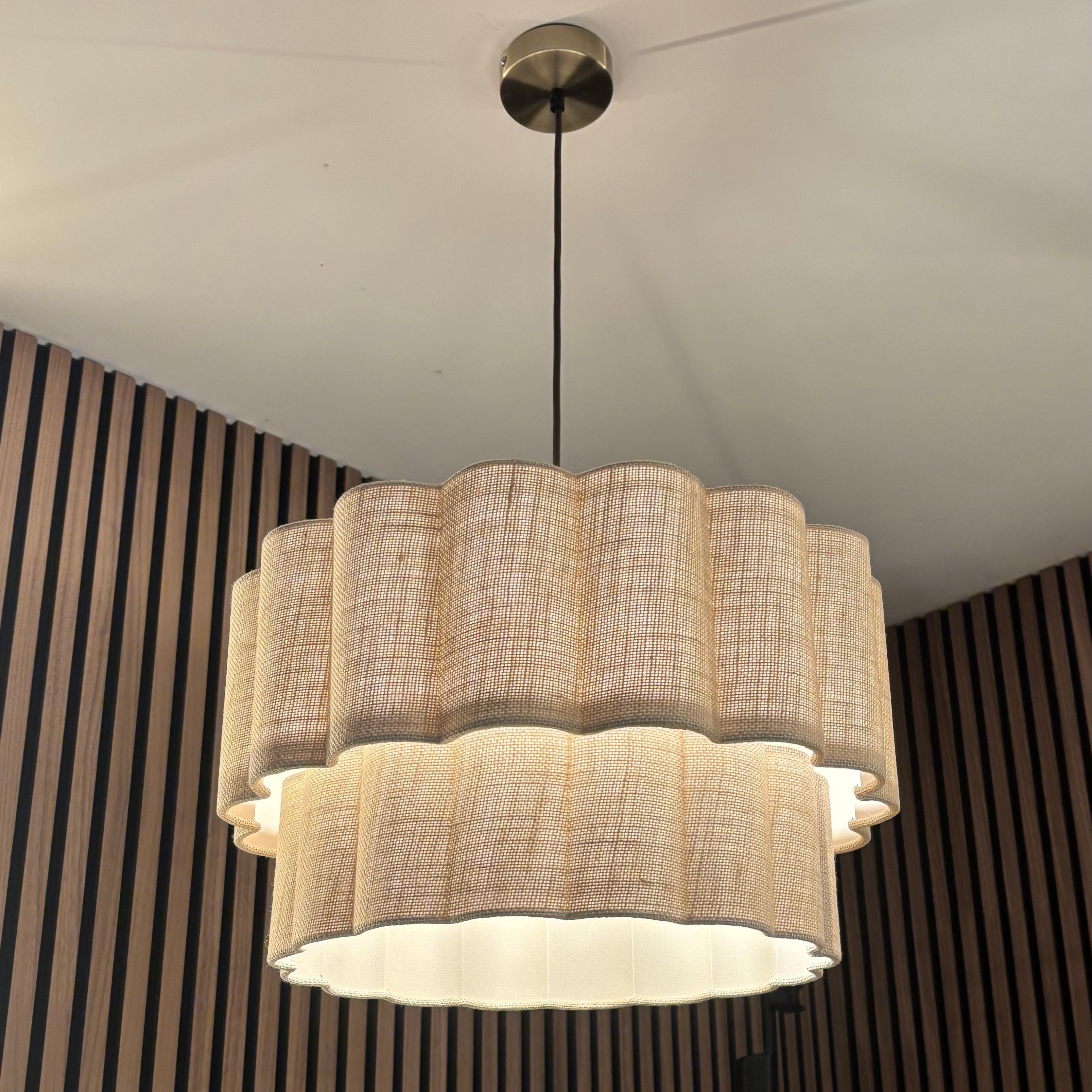 Chandelier with wicker design against a striped wall