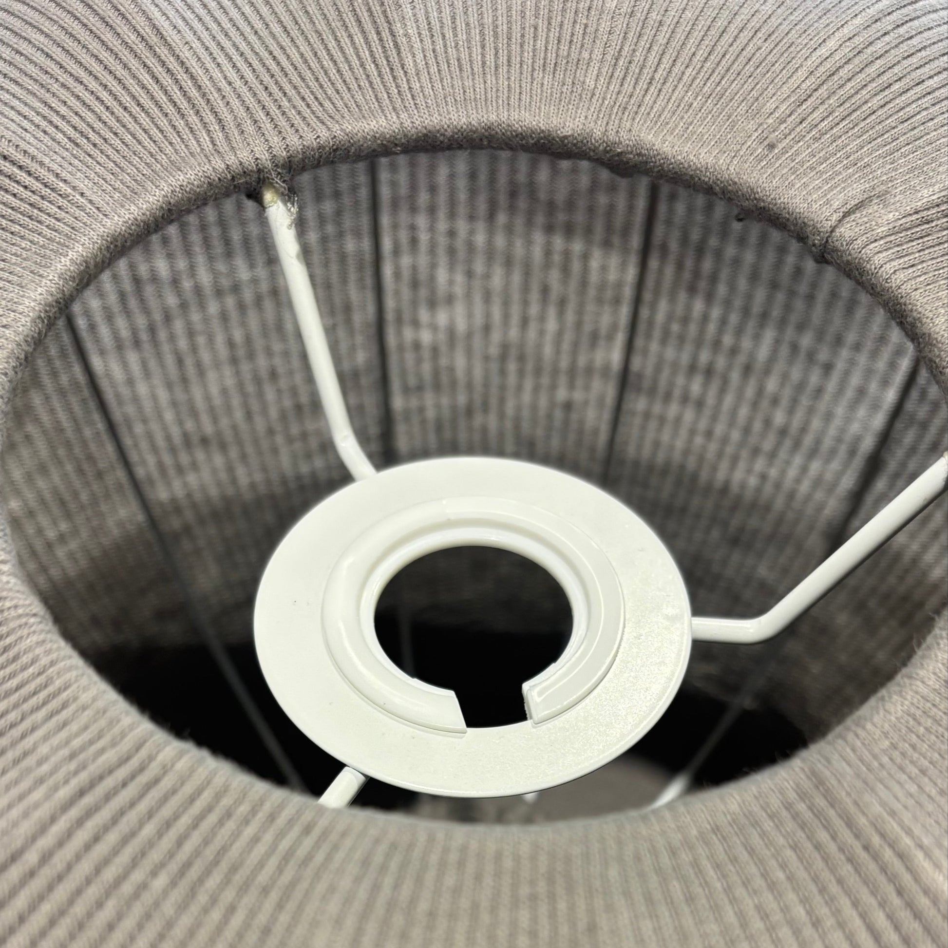 Close-up of a gray woven basket with a white circular object inside.