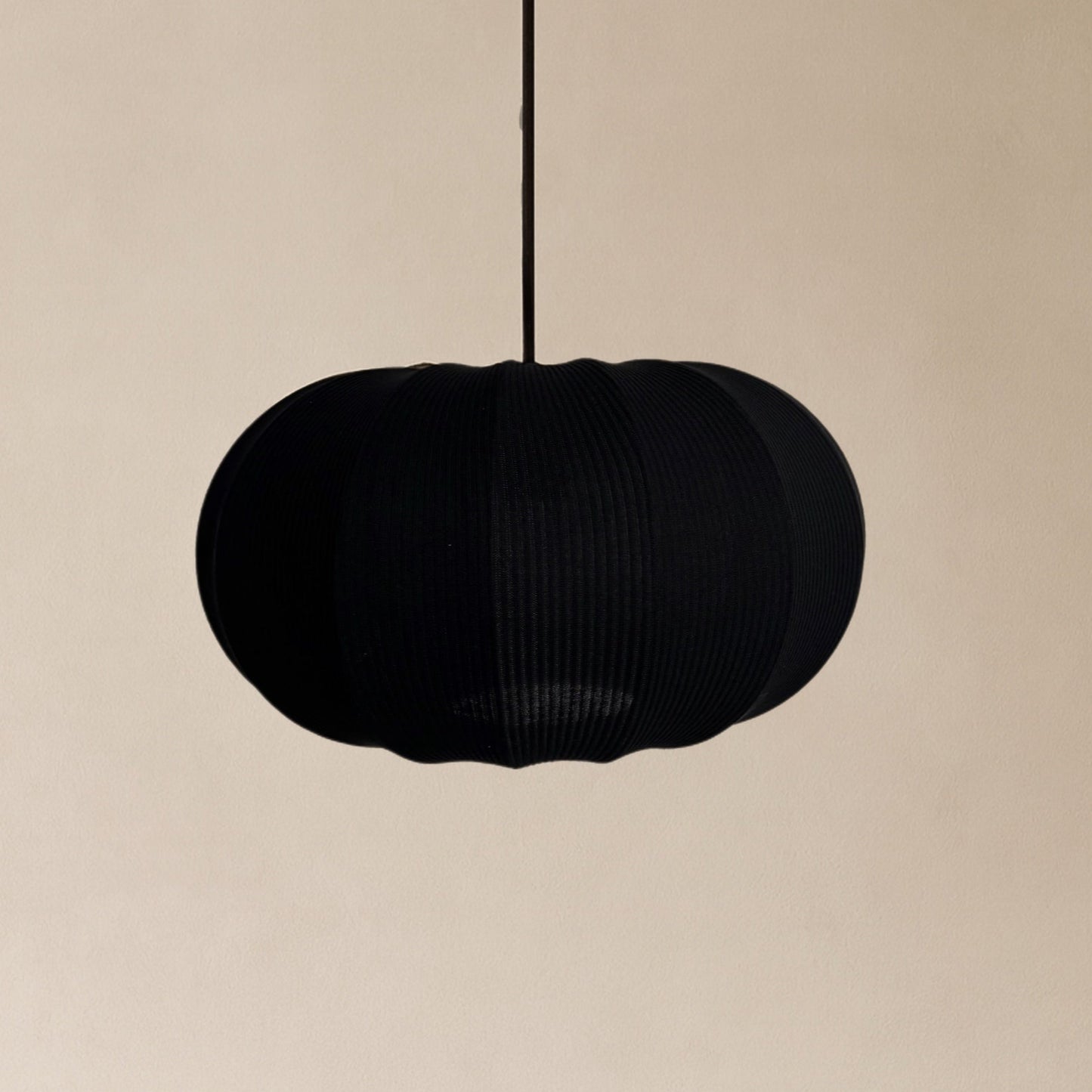 Black pendant lamp on a beige background