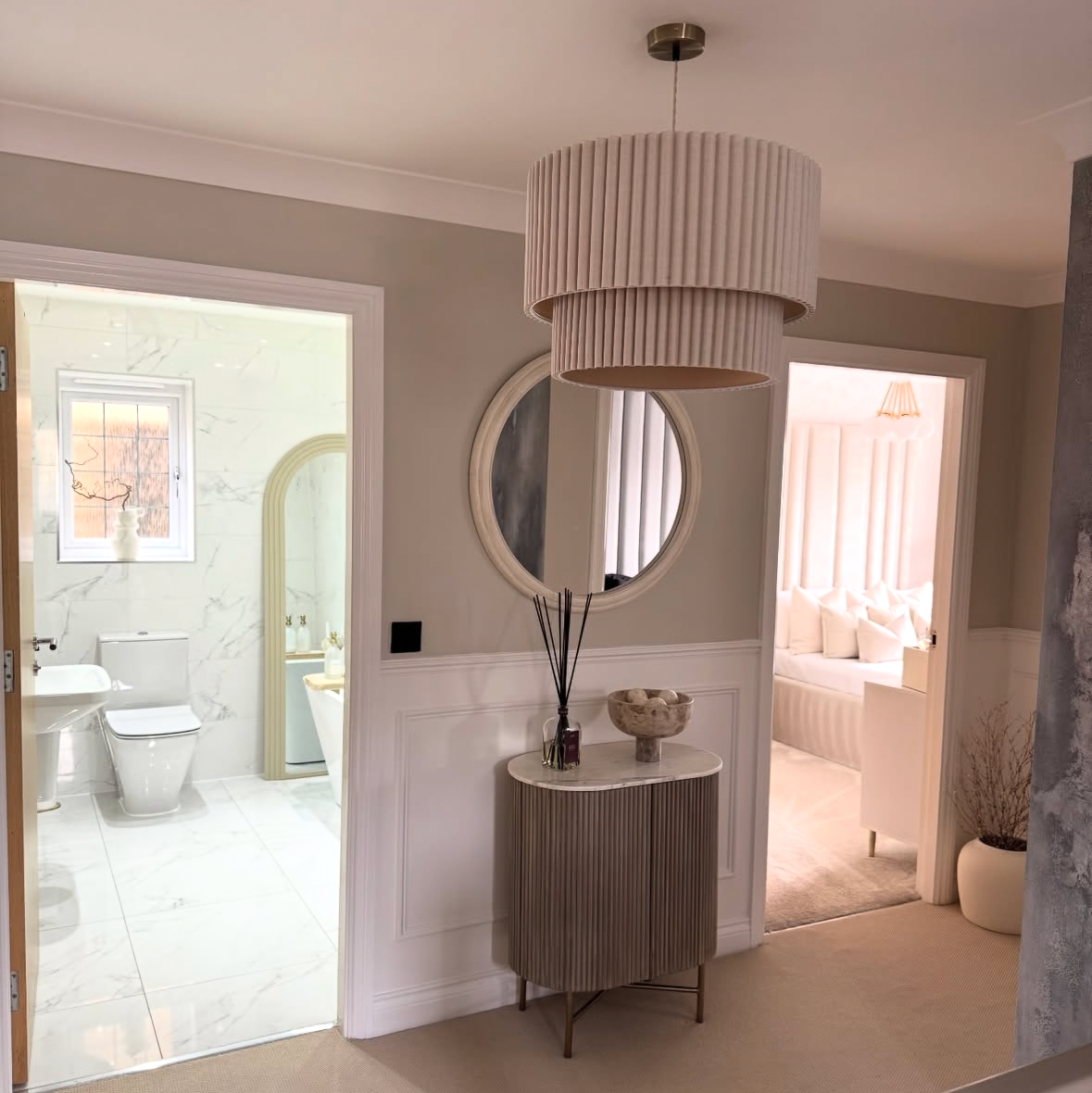 Modern interior design with a round mirror and light fixture.