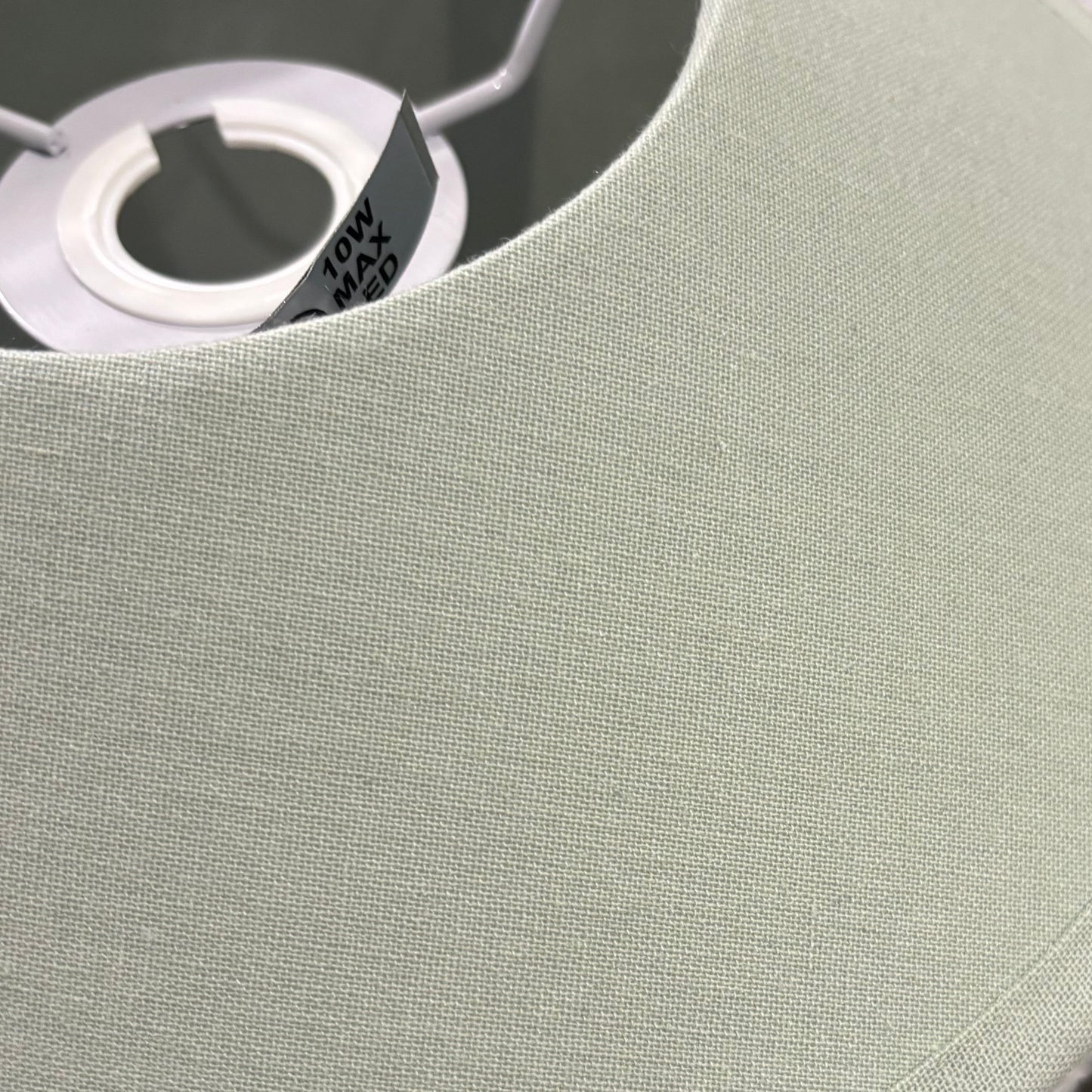 Round pastel green object with a central hole on a surface, partially covered by plastic wrap.