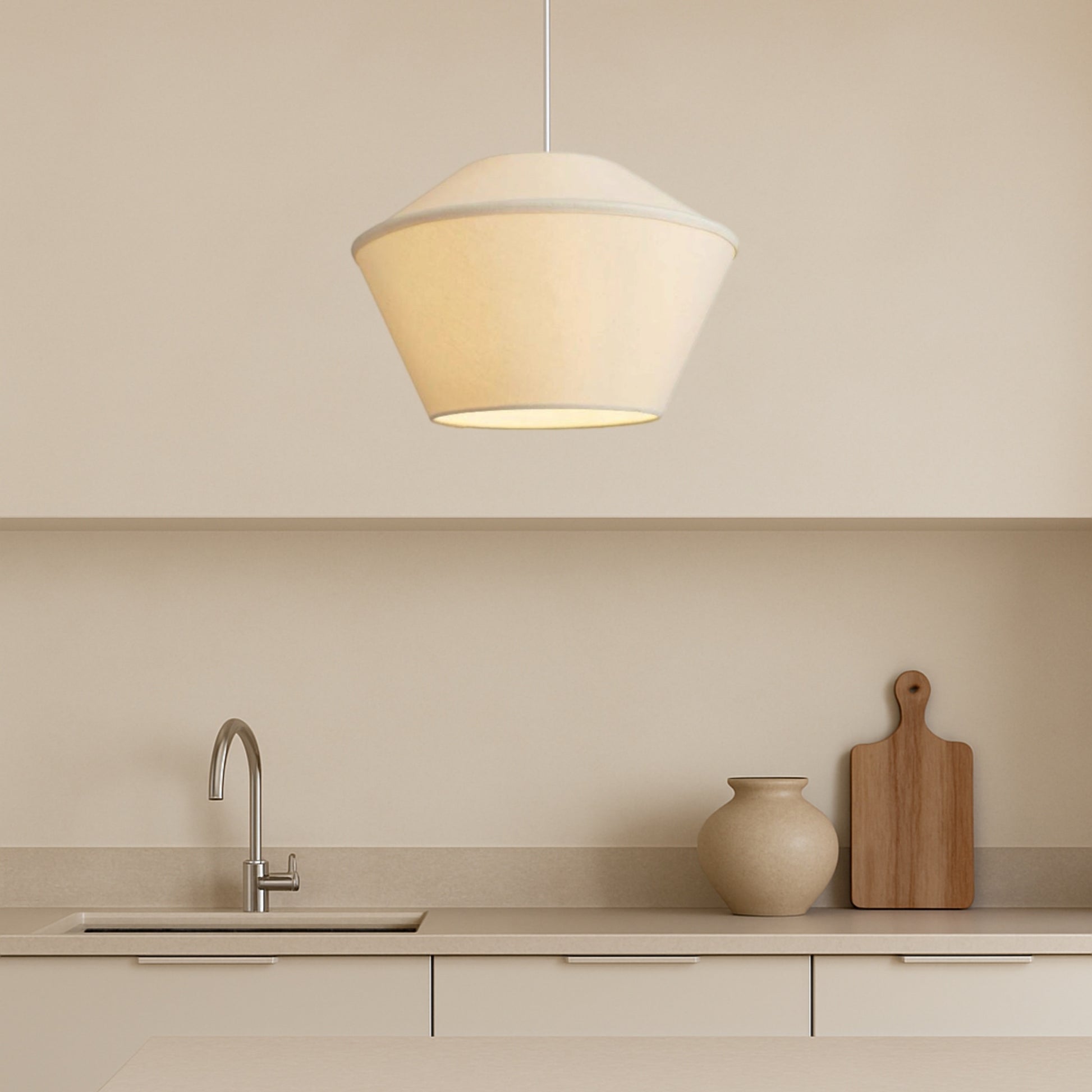 Modern kitchen with pendant light, sink, and decorative items on a neutral background