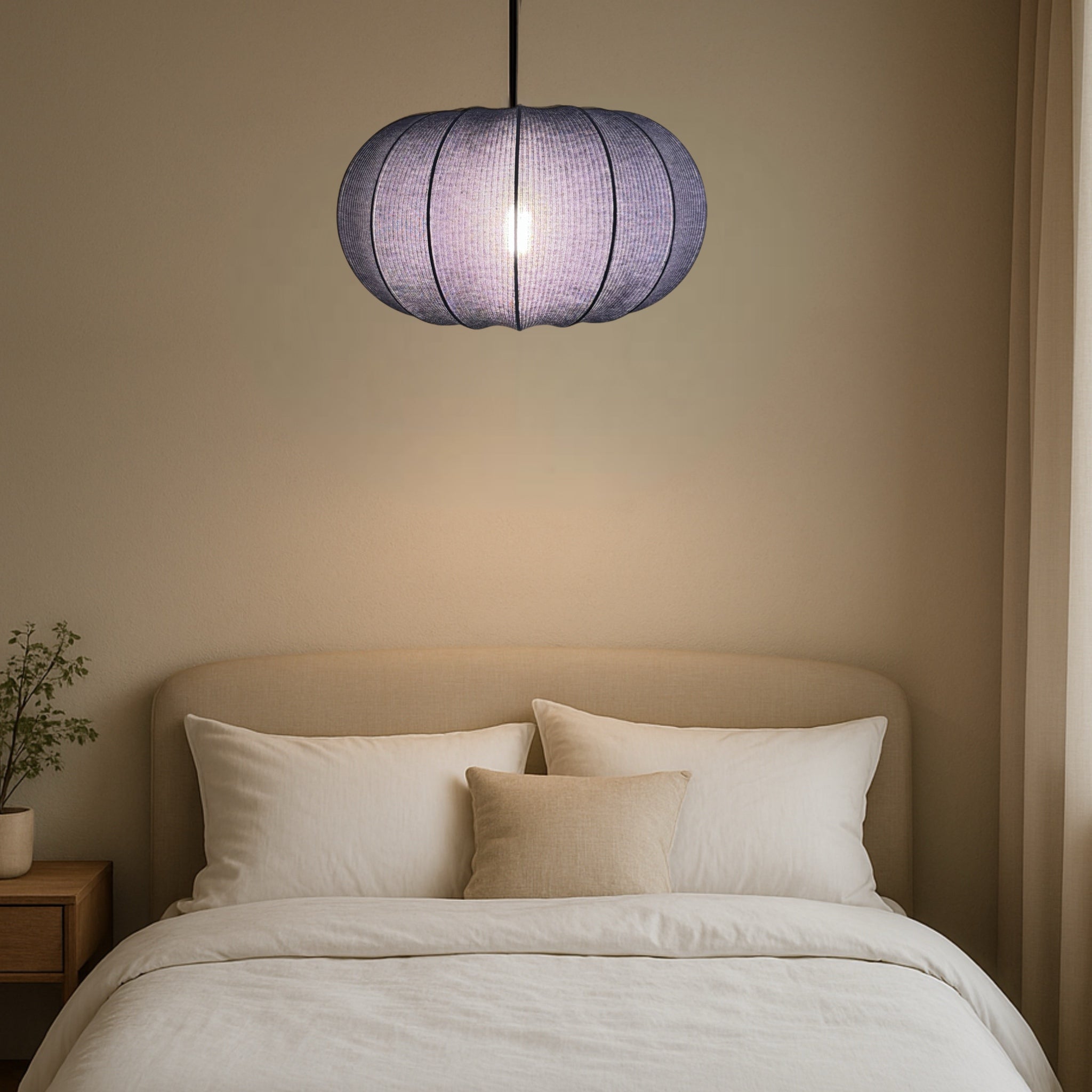 Navy pendant lamp hanging above a bed in a bedroom setting