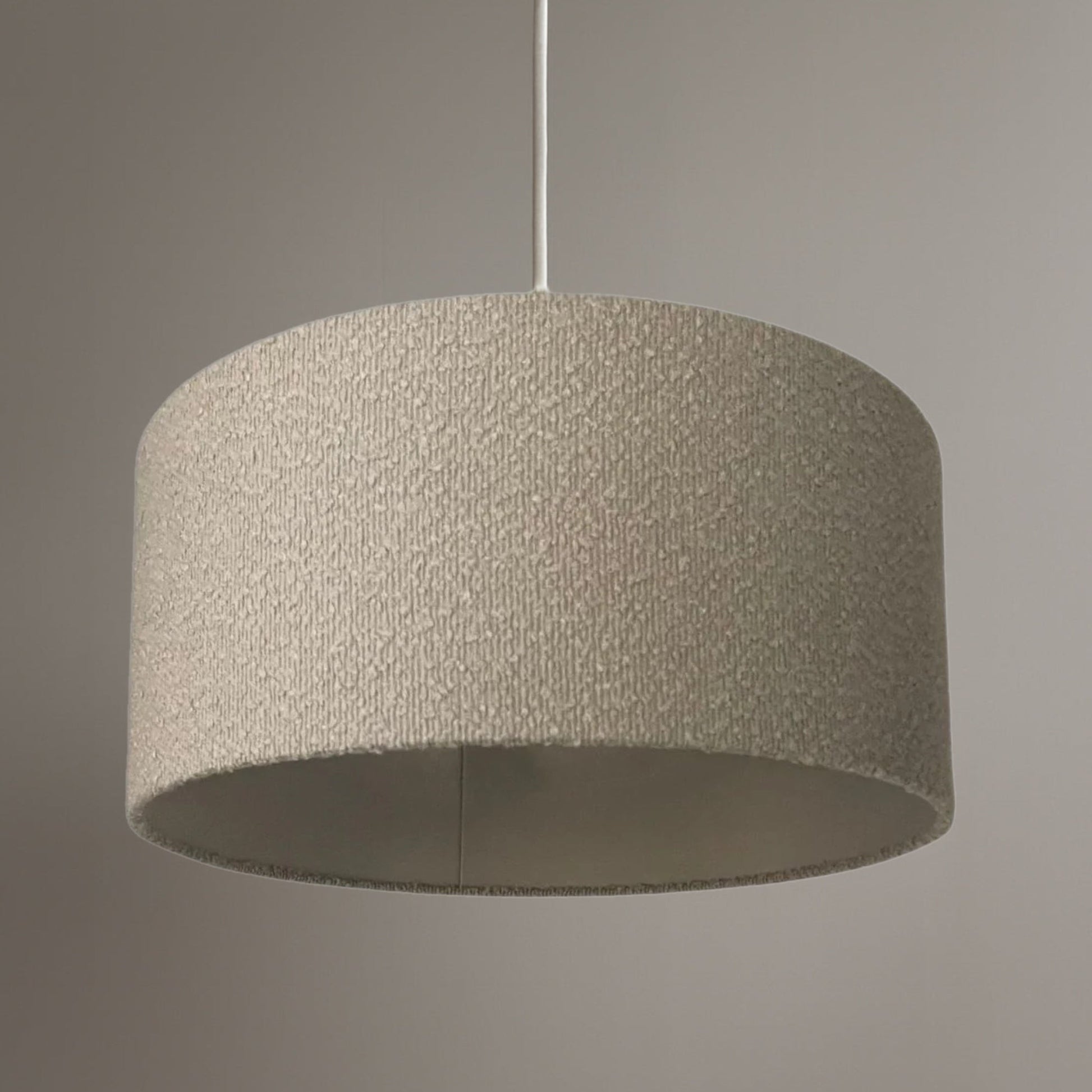 Textured grey pendant light against a neutral background