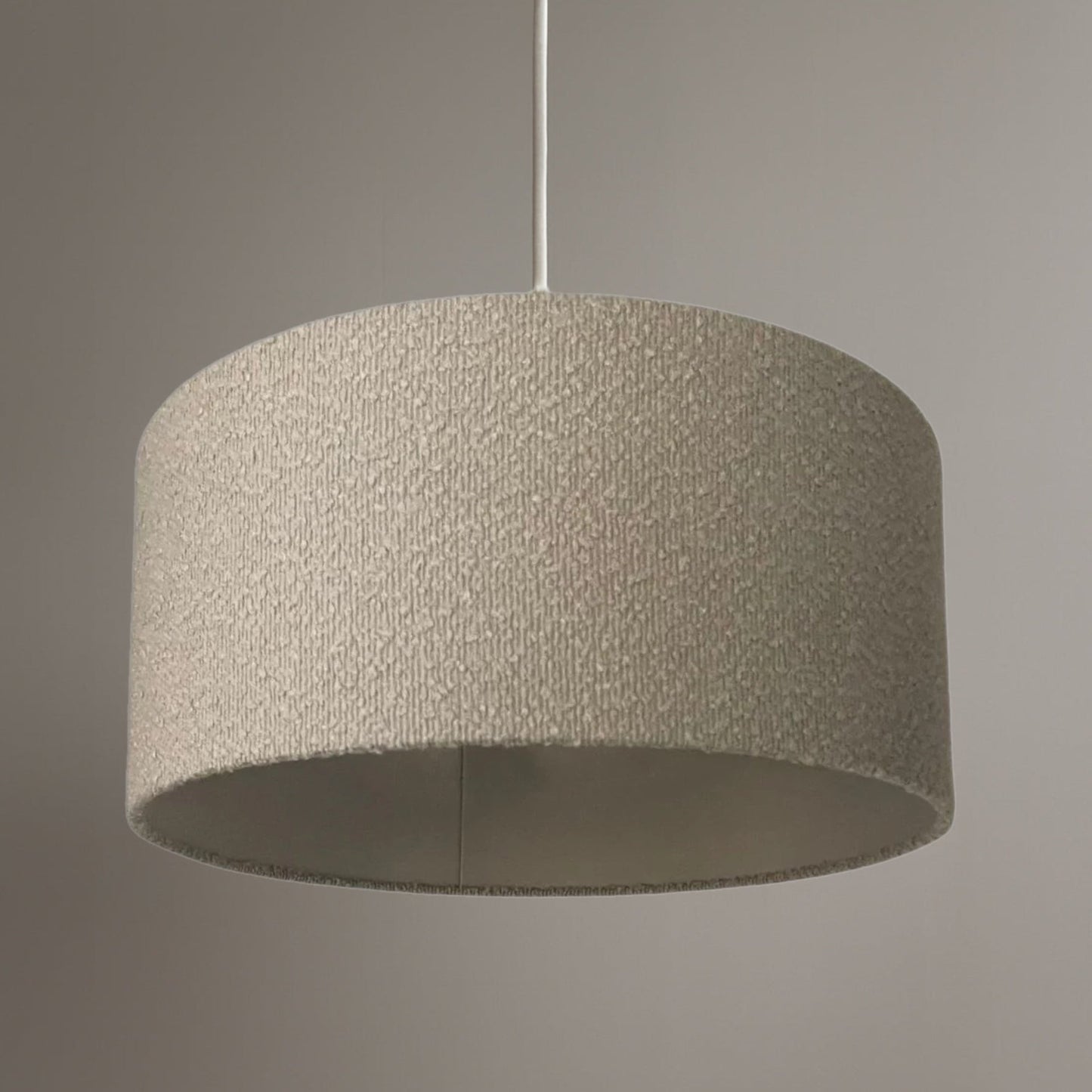 Textured grey pendant light against a neutral background