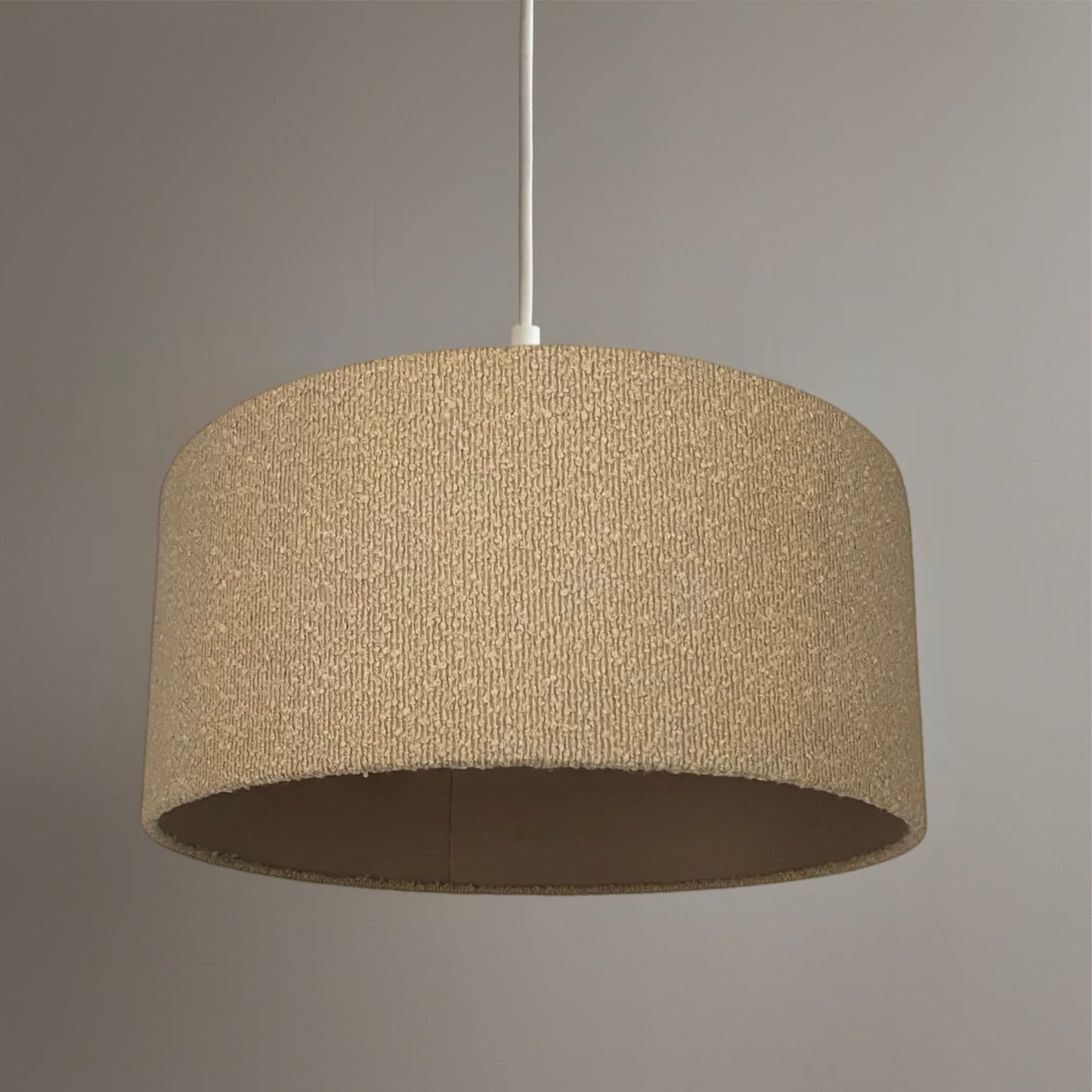 Beige textured pendant light against a gray background