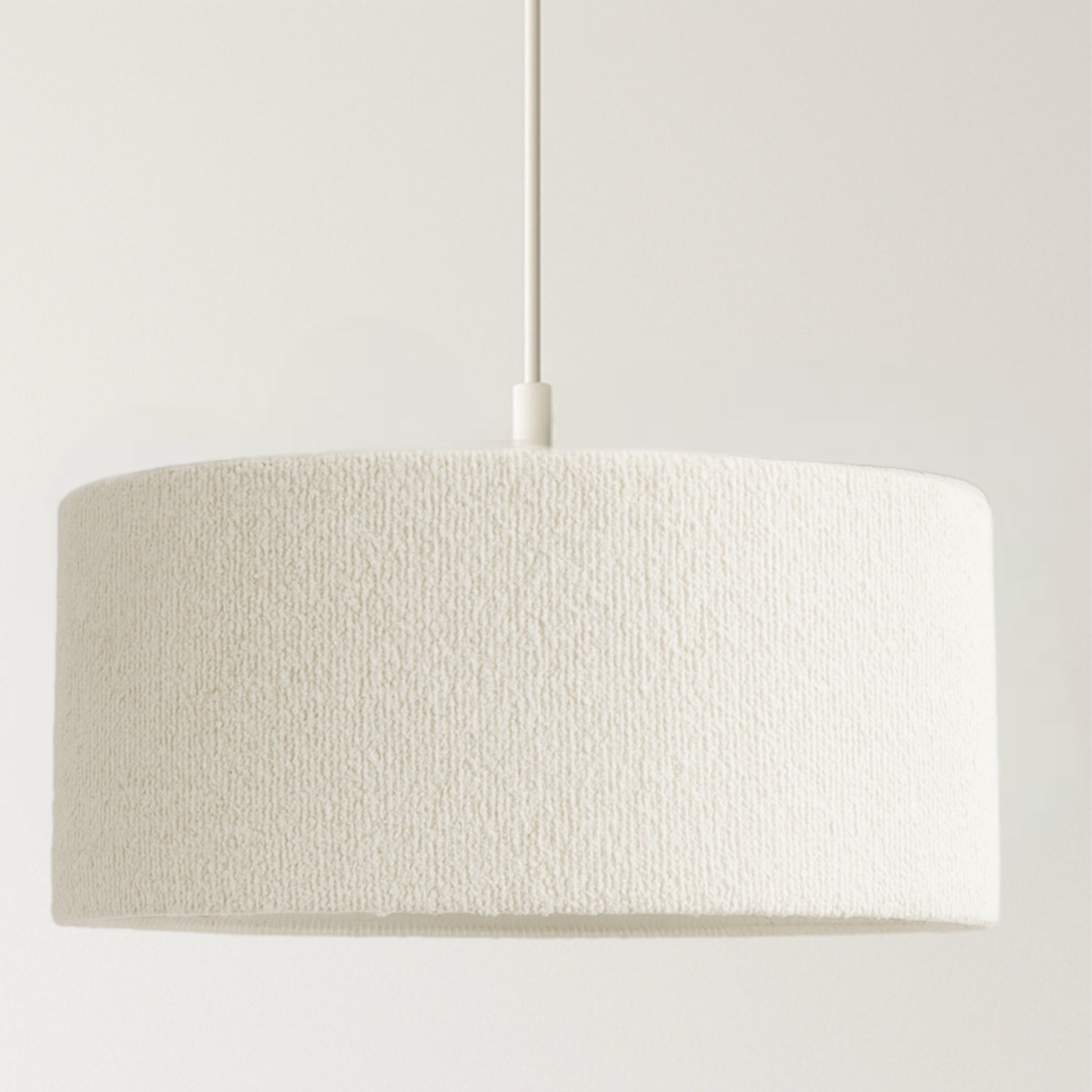 Textured beige pendant light on a white background