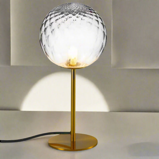 Introducing our Dixon table lamp with its elegant crystal and golden finish it will be sure to make a stylish addition to any living space. It features an ornate cut glass crystal globe design and is complimented by a brushed gold base that gives the light an undeniably luxurious style.