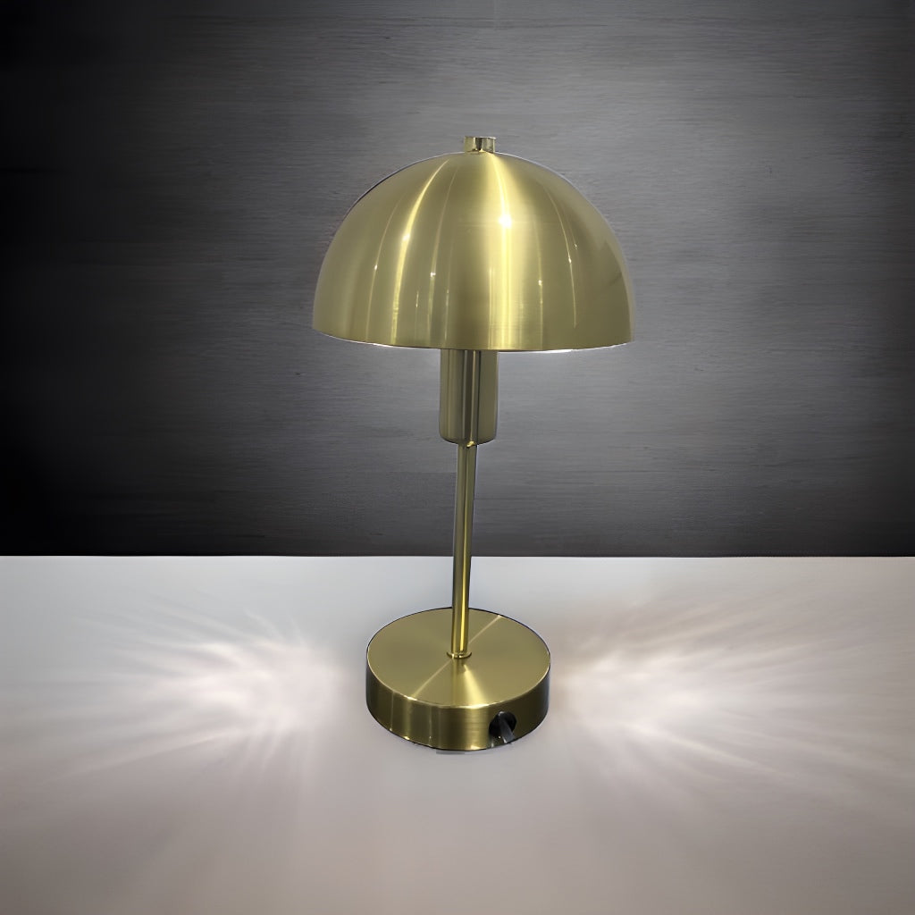 Our Nellie table lamp is a strong visual addition to your space with its distinctive dome-shaped shade and metal frame. Thanks to its brushed gold brass metal finish, it will suit both modern and traditional homes and commercial properties. Light reflects off the shade to enhance a warm and inviting glow.