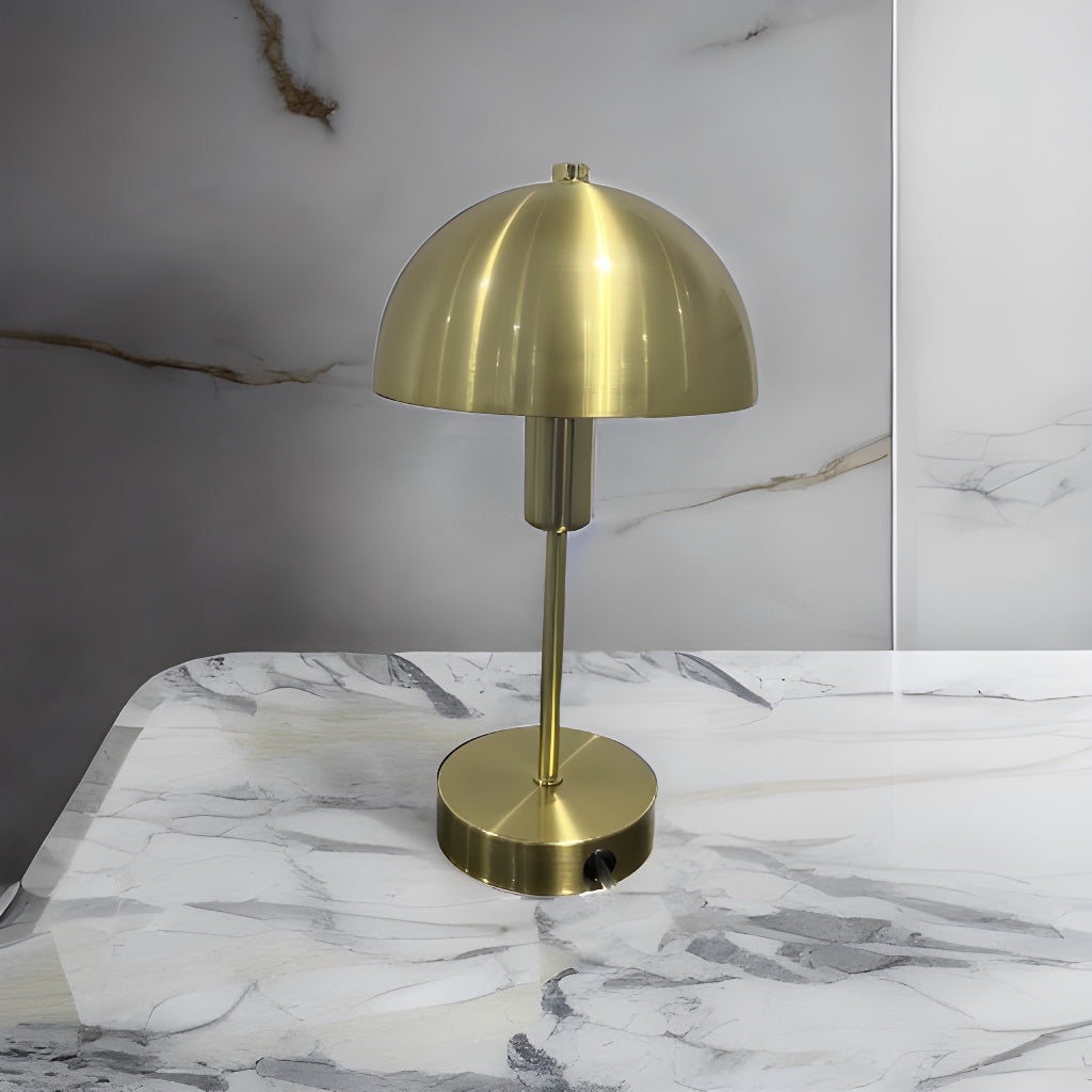 Our Nellie table lamp is a strong visual addition to your space with its distinctive dome-shaped shade and metal frame. Thanks to its brushed gold brass metal finish, it will suit both modern and traditional homes and commercial properties. Light reflects off the shade to enhance a warm and inviting glow.