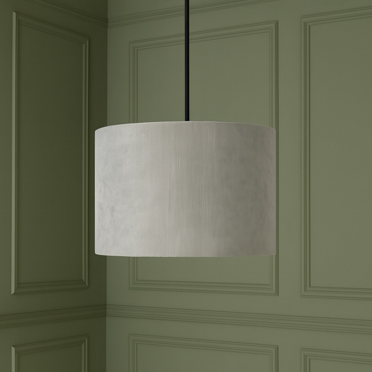 Beige pendant lamp hanging against a green paneled wall