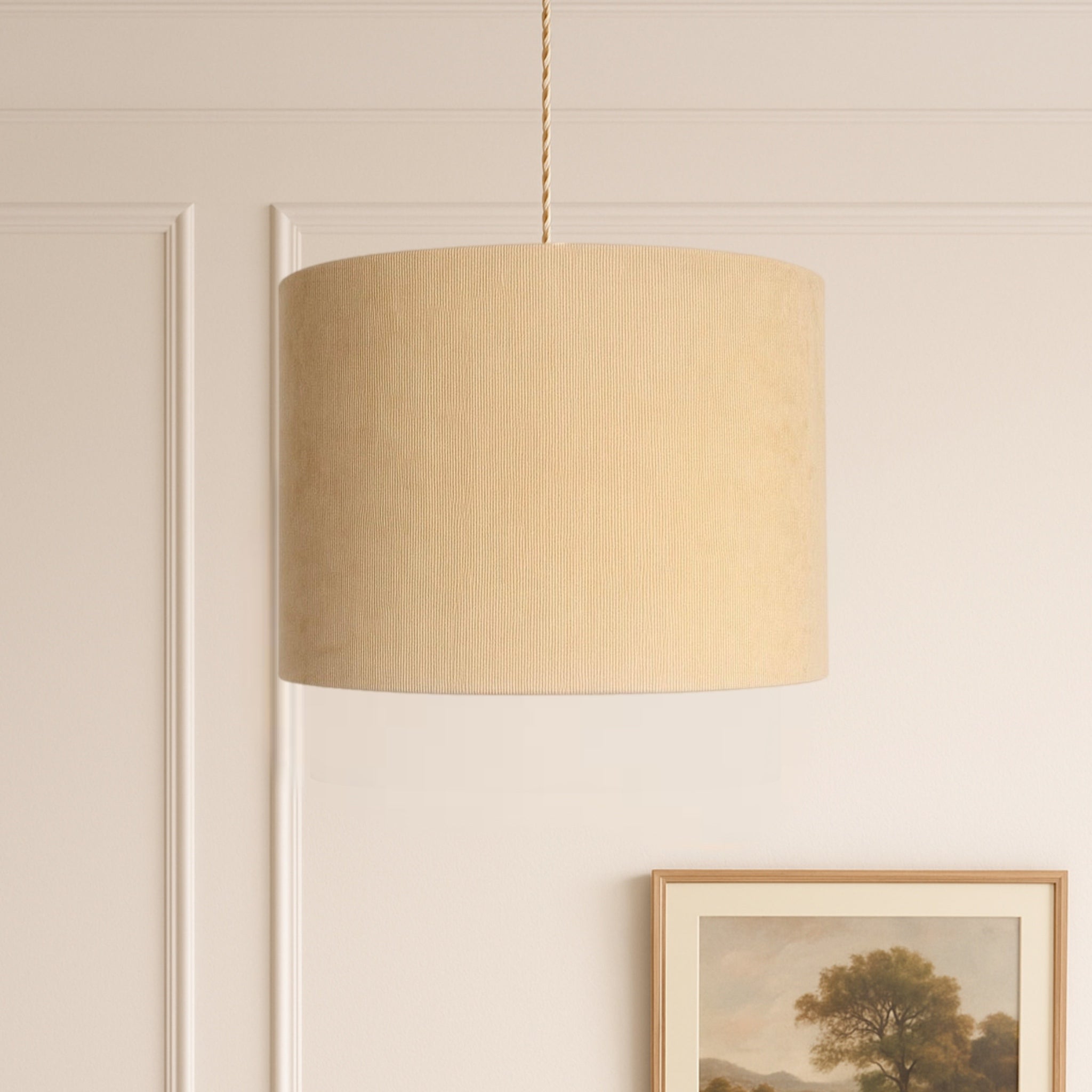 Beige pendant lamp hanging against a beige wall with a framed picture below.