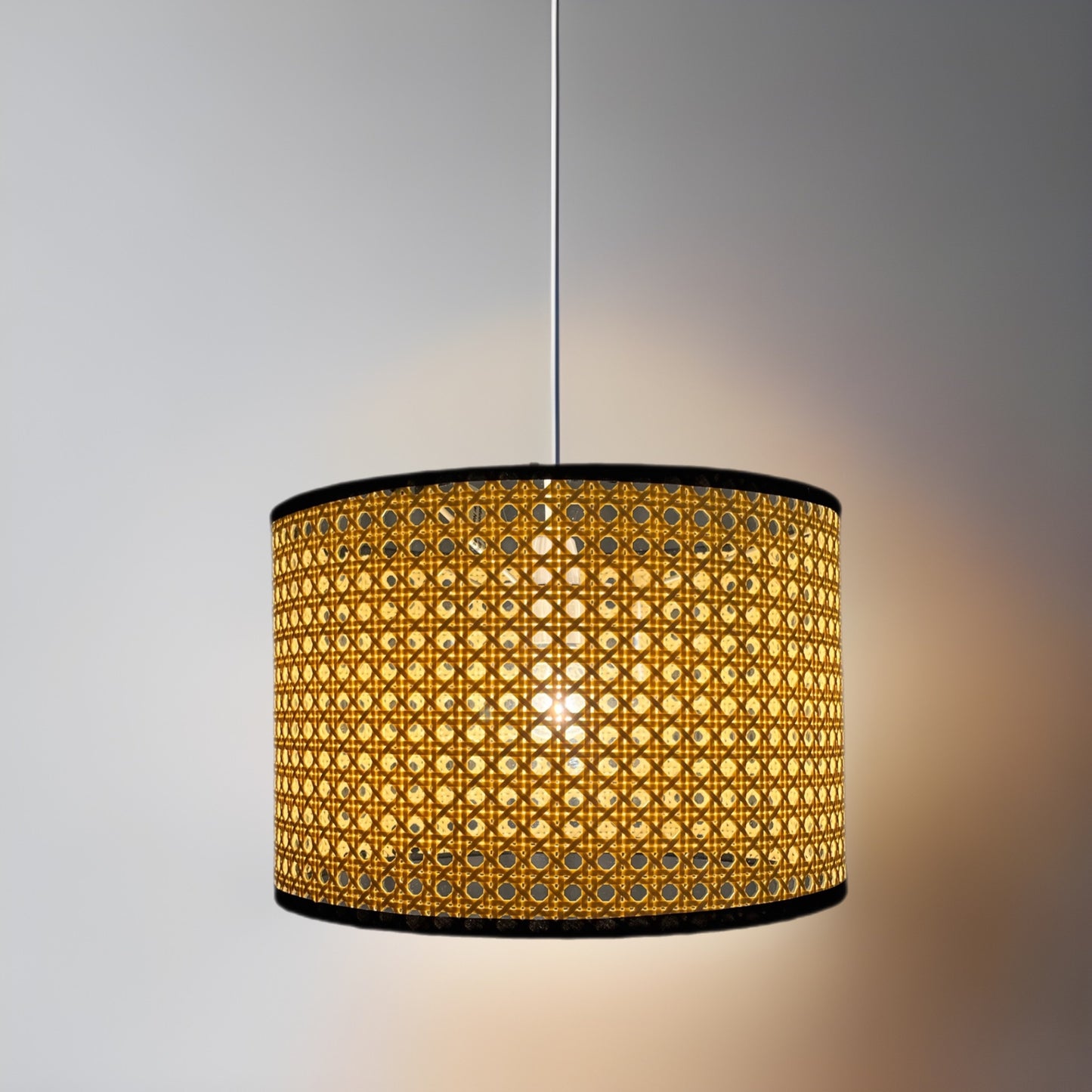 Traditional and sleek drum shaped easy fit pendant light shade with woven rattan frame. Simply attaches to your existing pendant wire cable. Finished in a unique light brown material in a woven style and complete with a black cotton trim giving this product a very natural and minimalist finish. This fantastic shade can double up as either a ceiling pendant light shade or table lampshade. 