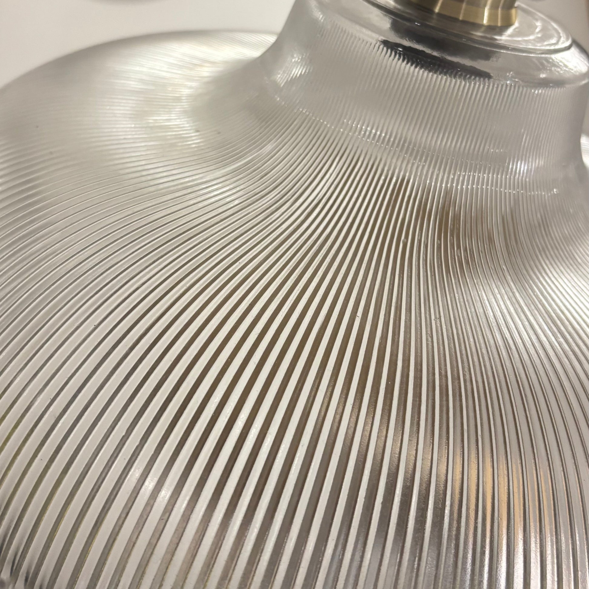 Close-up of a industrial lamp with ribbed glass shade and metal fitting.