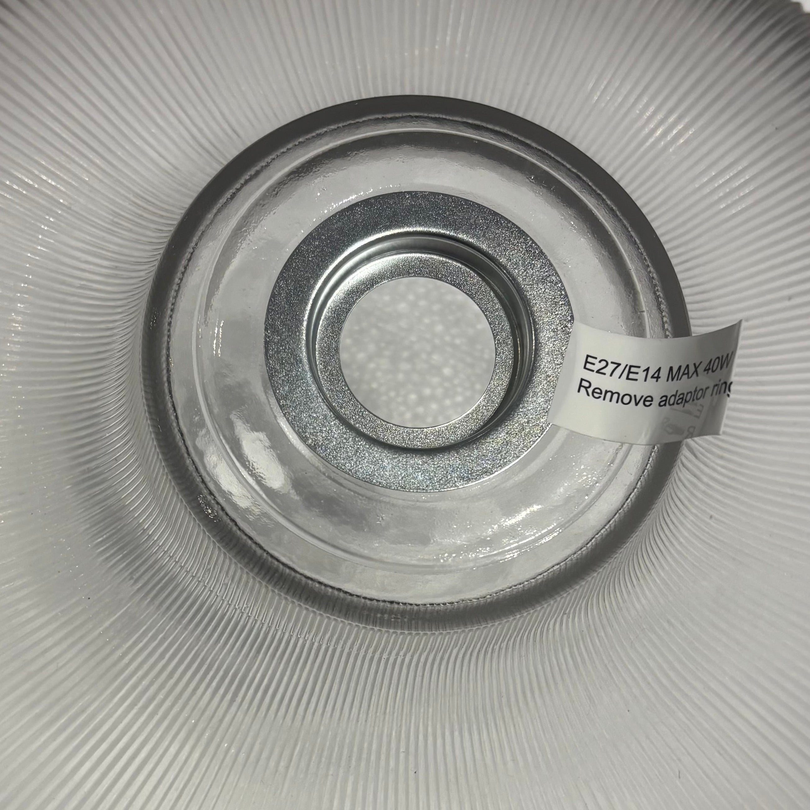 Clear glass light fixture with a label on a white background