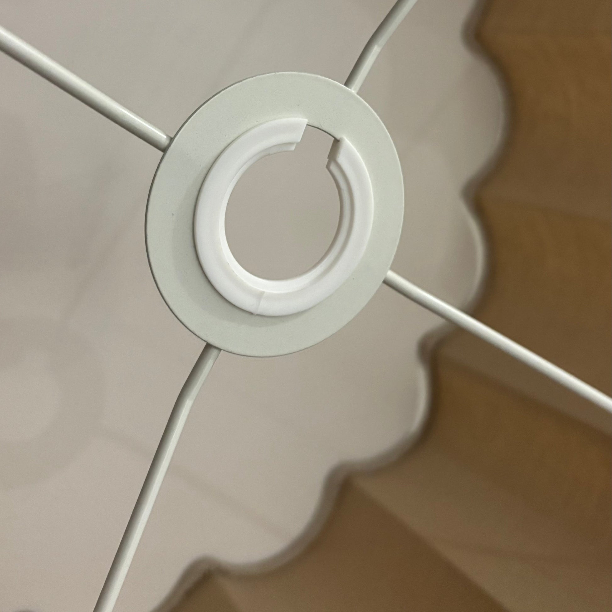 Close-up of a white ceiling light fixture with scalloped edge