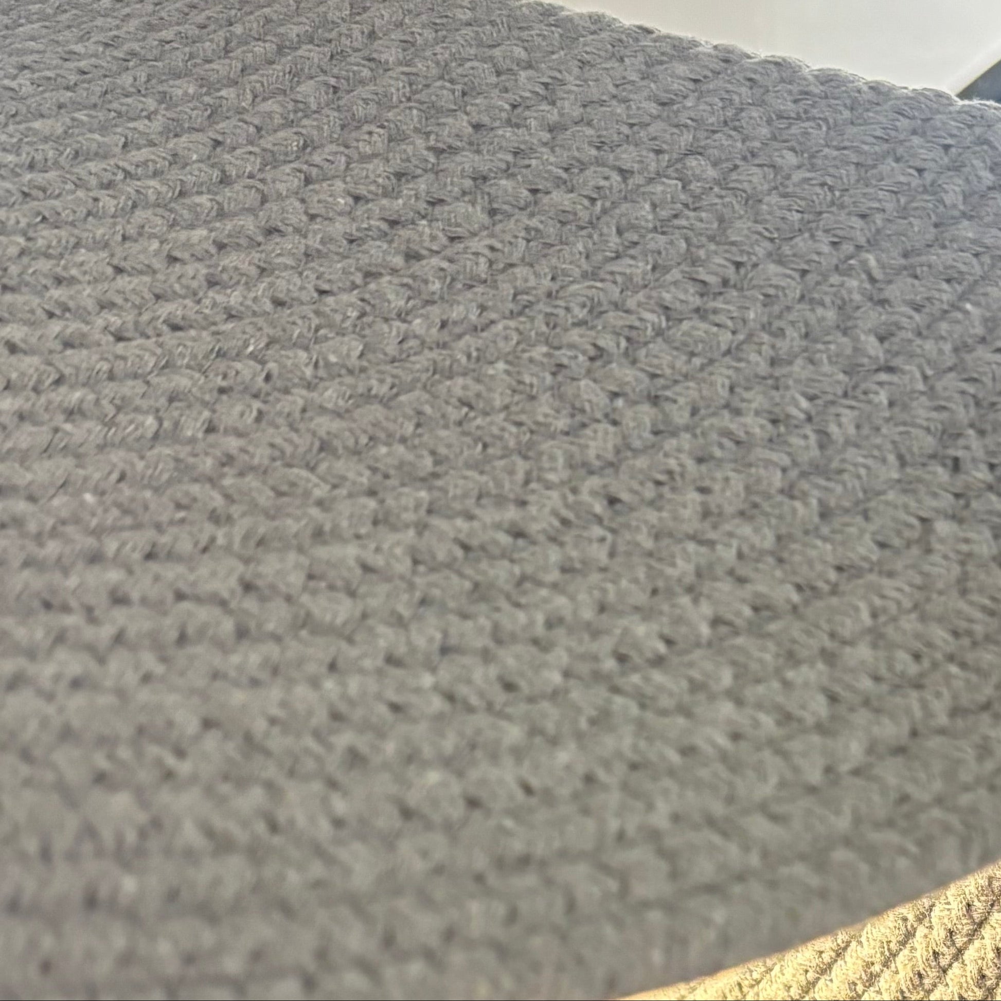 Close-up of textured gray fabric with a gold border