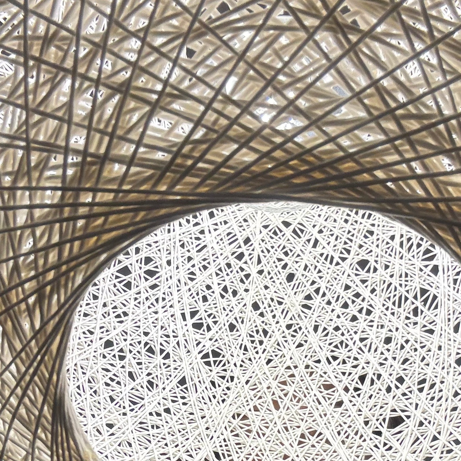 Person wearing a straw hat with a white circular pattern on a blurred background