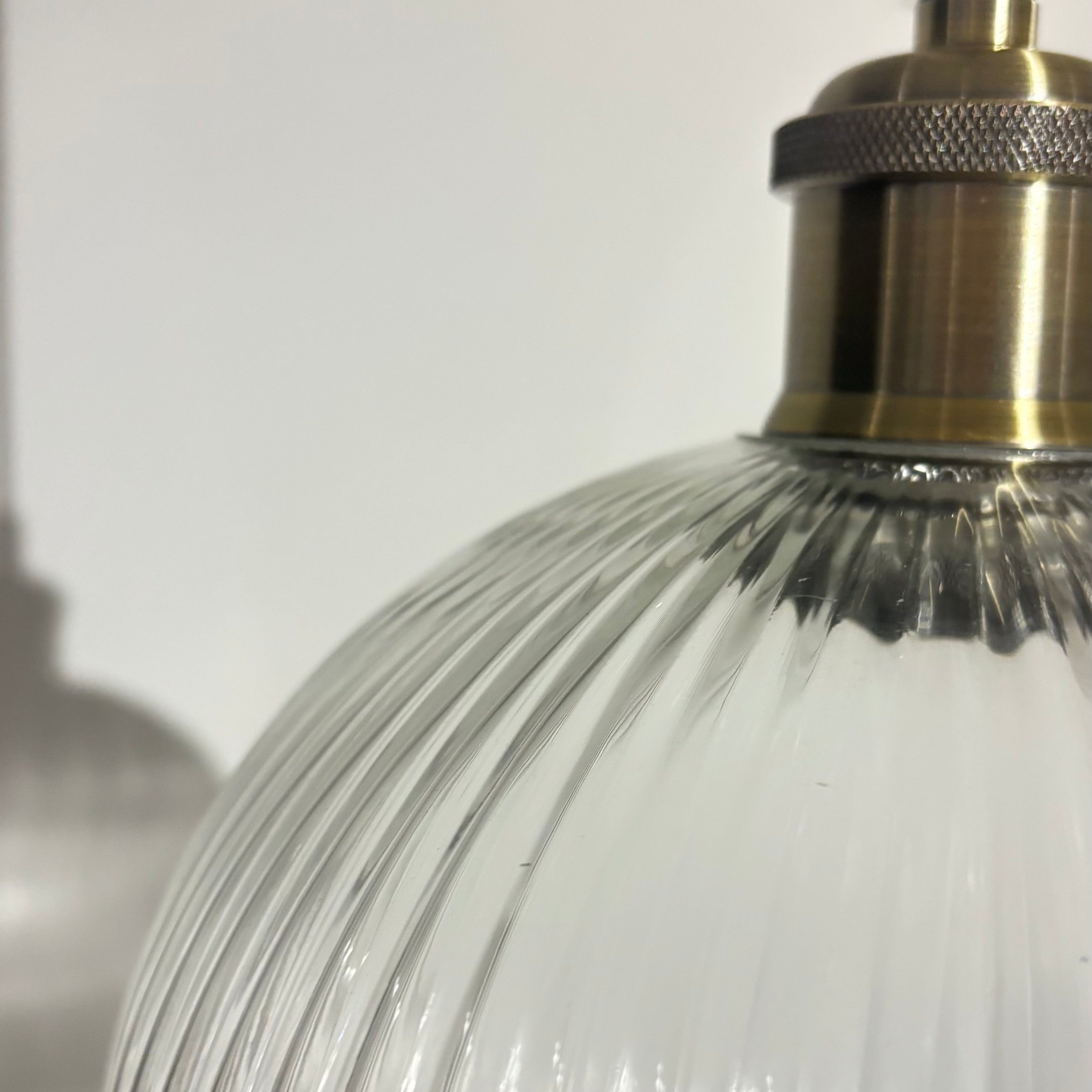 Close-up of a glass lampshade with metallic fixture on a white background