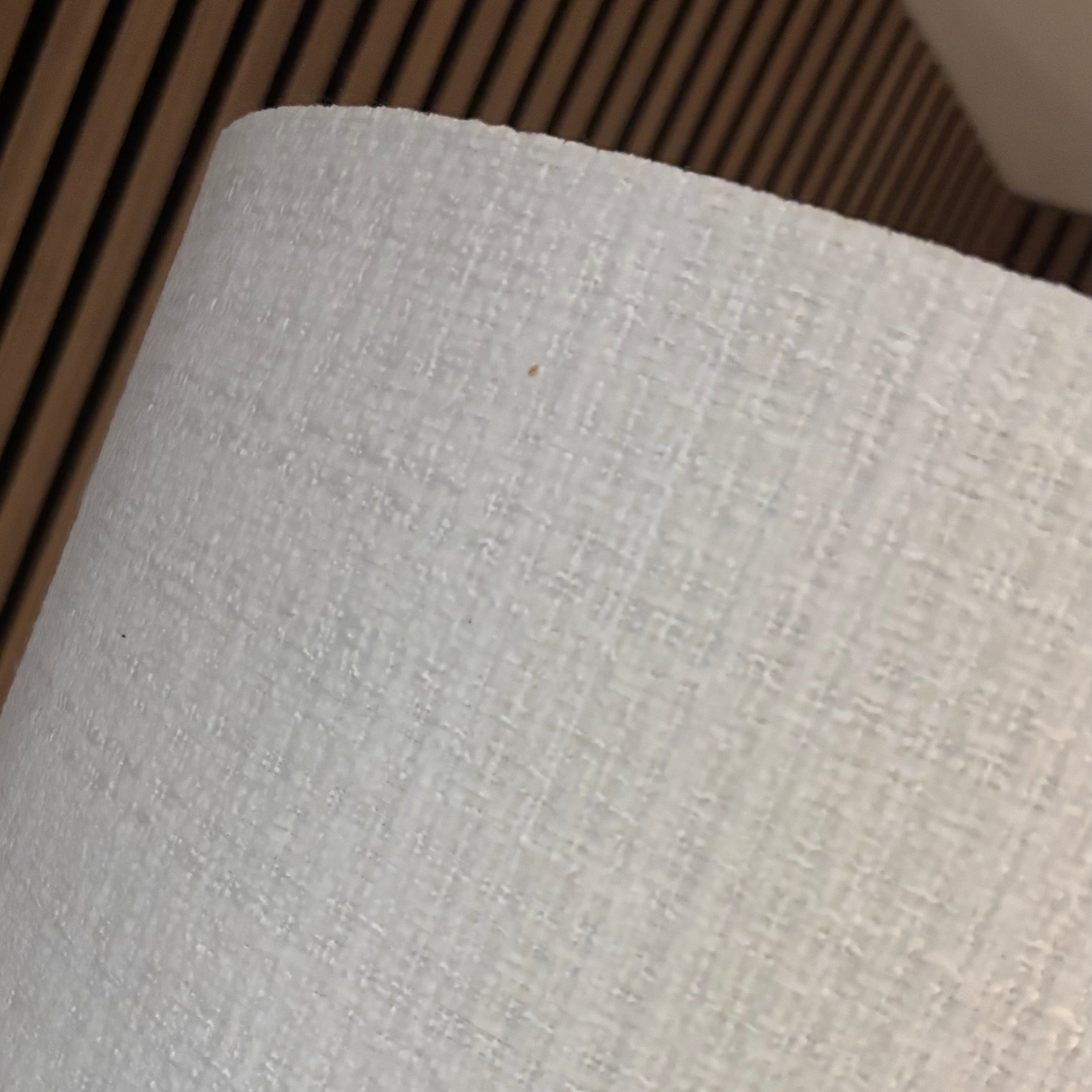 A close-up of a light gray textured fabric lampshade, showing its woven linen-like pattern.