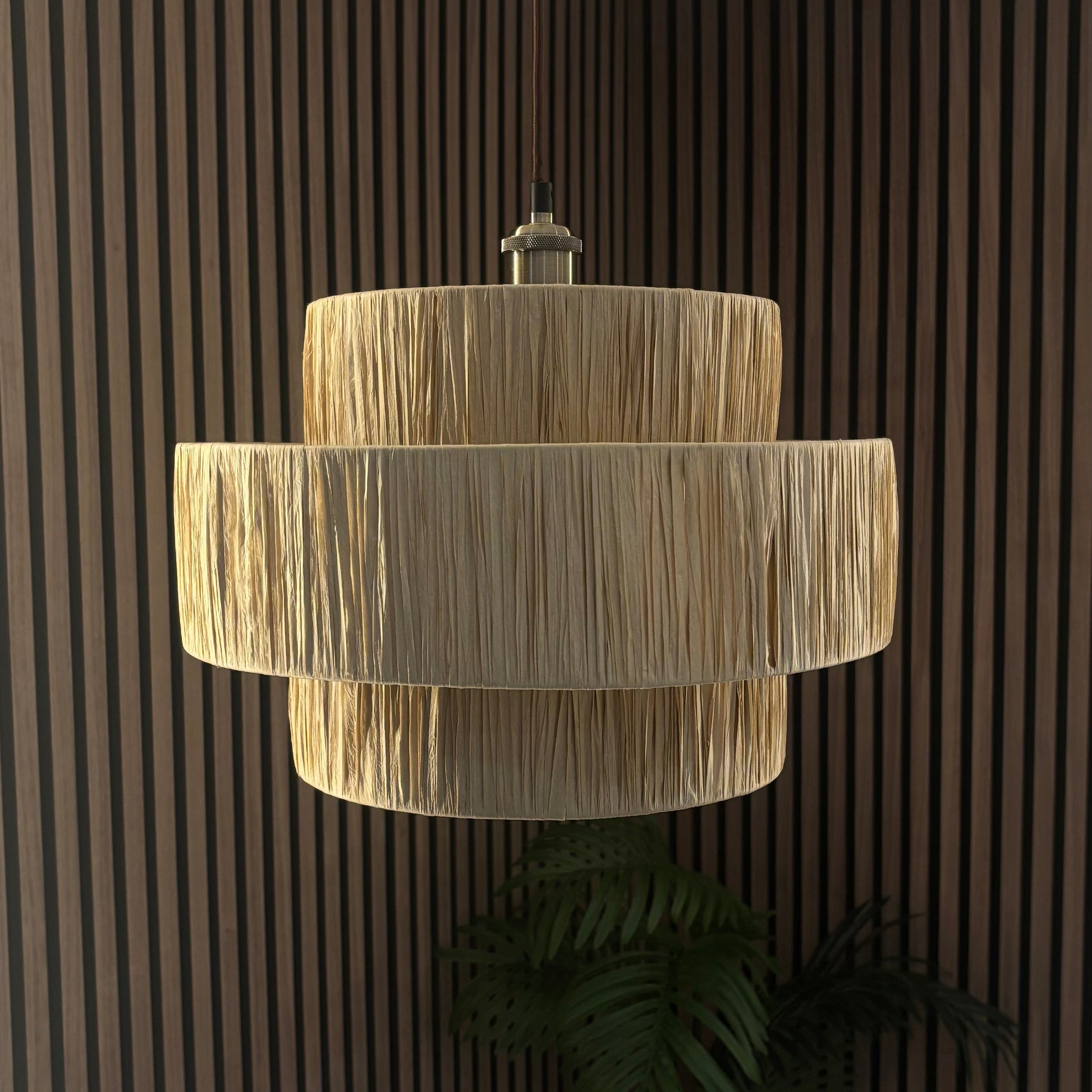 Beige layered pendant light against a dark wooden paneled wall