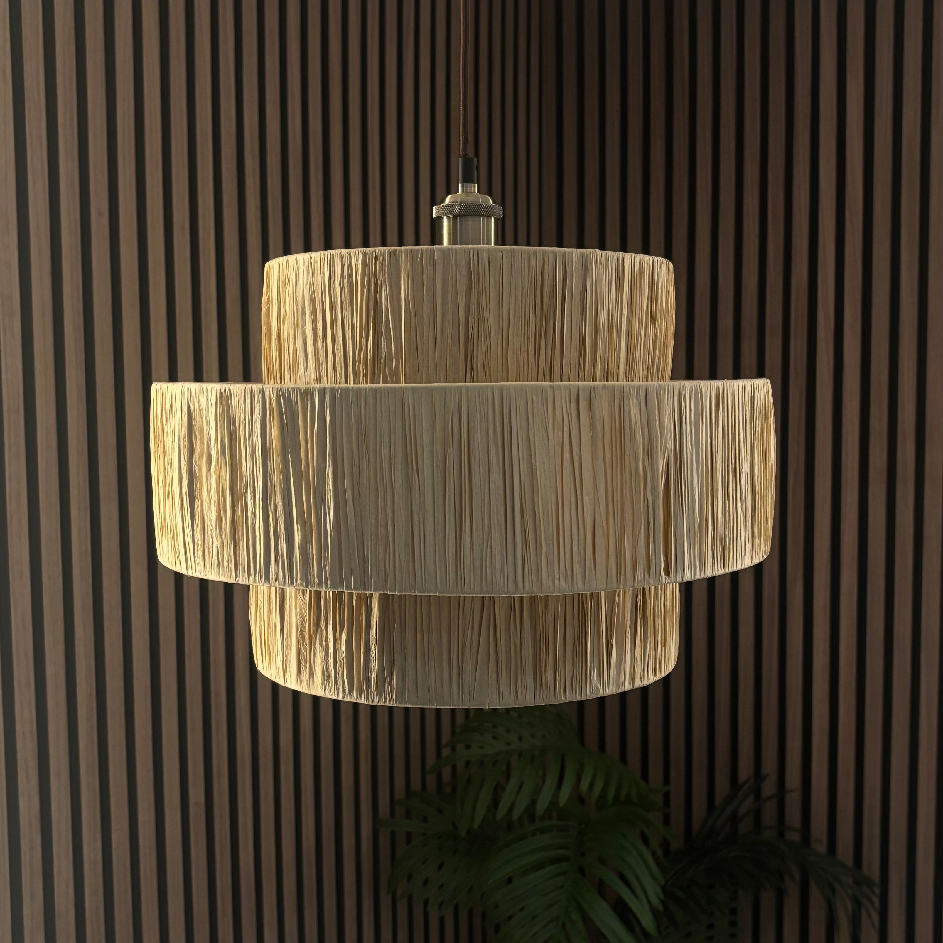 Beige layered pendant light against a dark wooden paneled wall