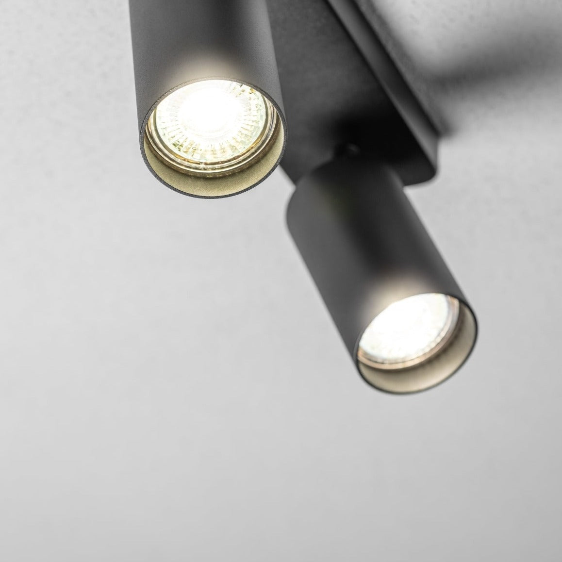 The black Nell twin lamp consists of two cylindrical spotlights, both of which can be tilted and adjusted on their own axis. The spotlights are attached to a rectangular bracket, which makes them equally suitable for mounting on walls and ceilings. Made of an aluminium body and powder coated black, the lamp with its simple design fits well into different spaces.