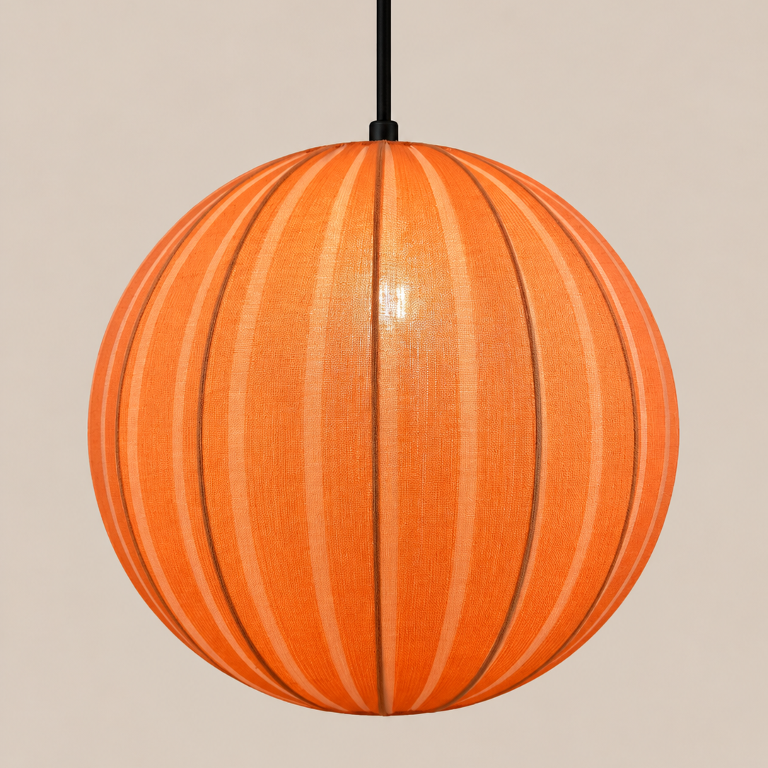 An orange spherical pendant light with vertical ribbed panels and a black hanging cord, shown against a plain beige background.