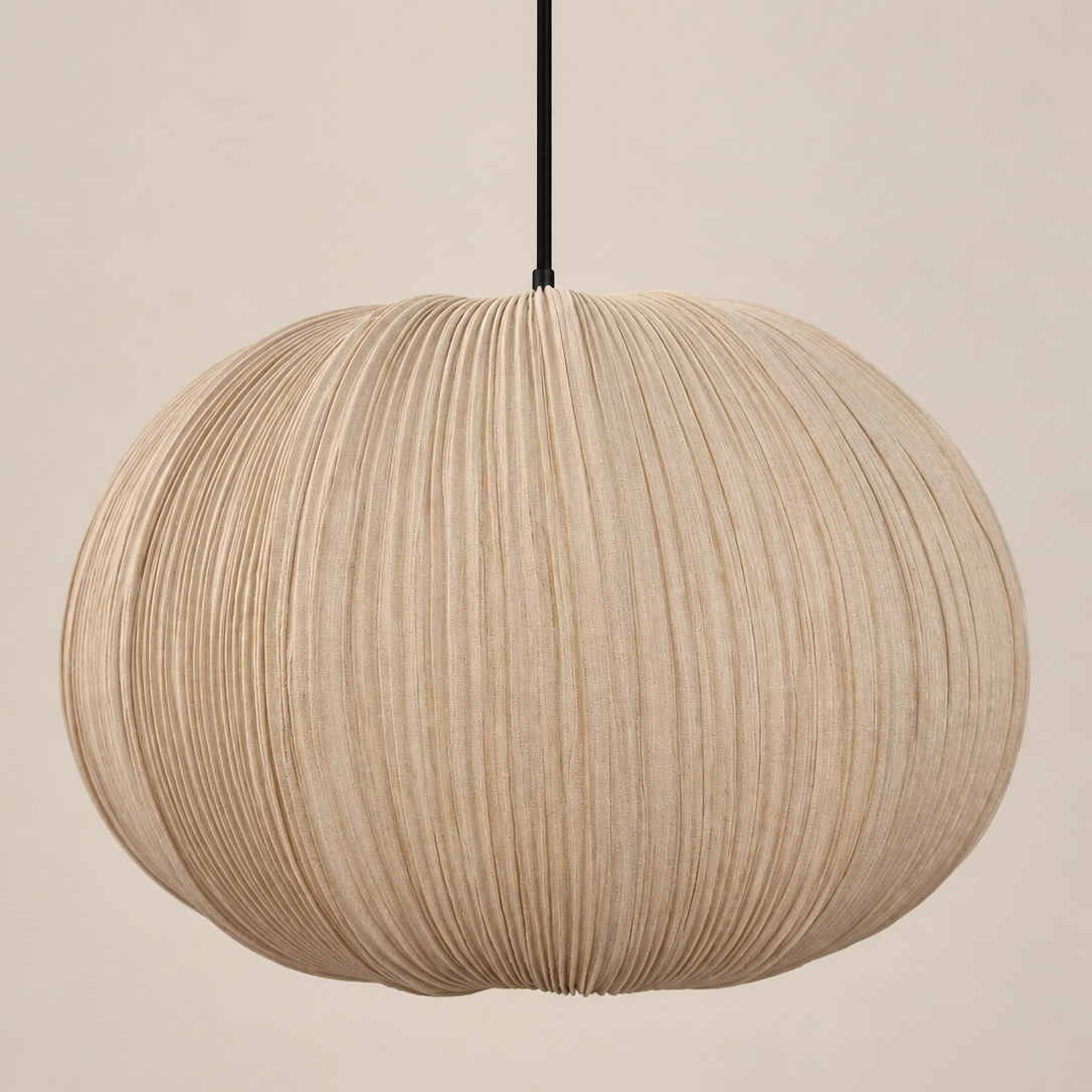 A spherical pleated paper pendant light in a natural beige color, suspended by a thin black cord against a solid beige background.