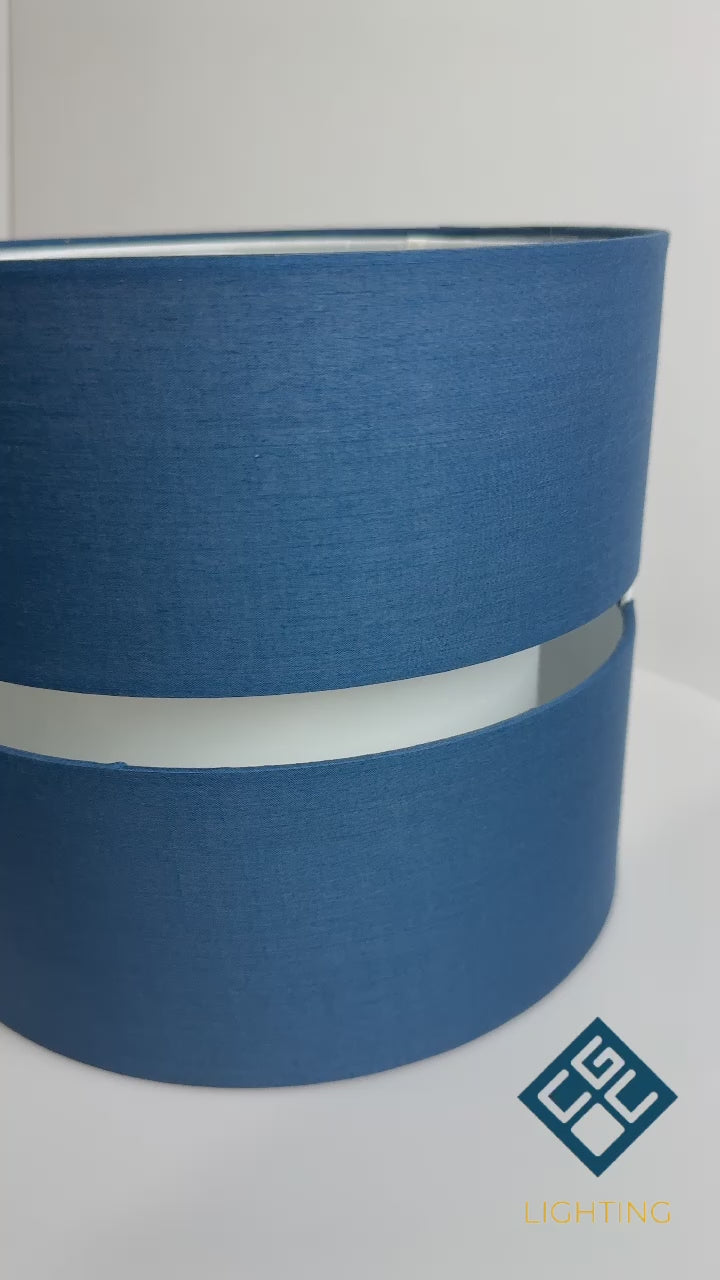 Load video: Our Navy Gayle two tiered luxury fabric double layered shade is contemporary in its appearance and we have designed the shade to suit a range of interiors. Easy to fit simply attached to an existing pendant flitting. It is crafted from high quality fabric material in two layers and complimented with a white inner which looks beautiful when light shines through. The shade has been made to fit both a ceiling light or lamp base.
