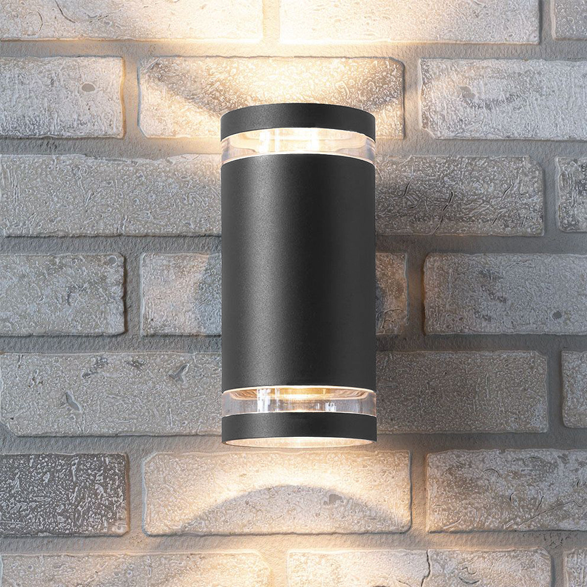 Our Jennifer dark grey outdoor wall mounted up and down cylinder outdoor light would look perfect in a modern or more traditional home design. Outside wall lights can provide atmospheric light in your garden, at the front door or on the terrace as well as a great security solution. It is designed for durability and longevity with its robust material producing a fully weatherproof and water resistant light fitting