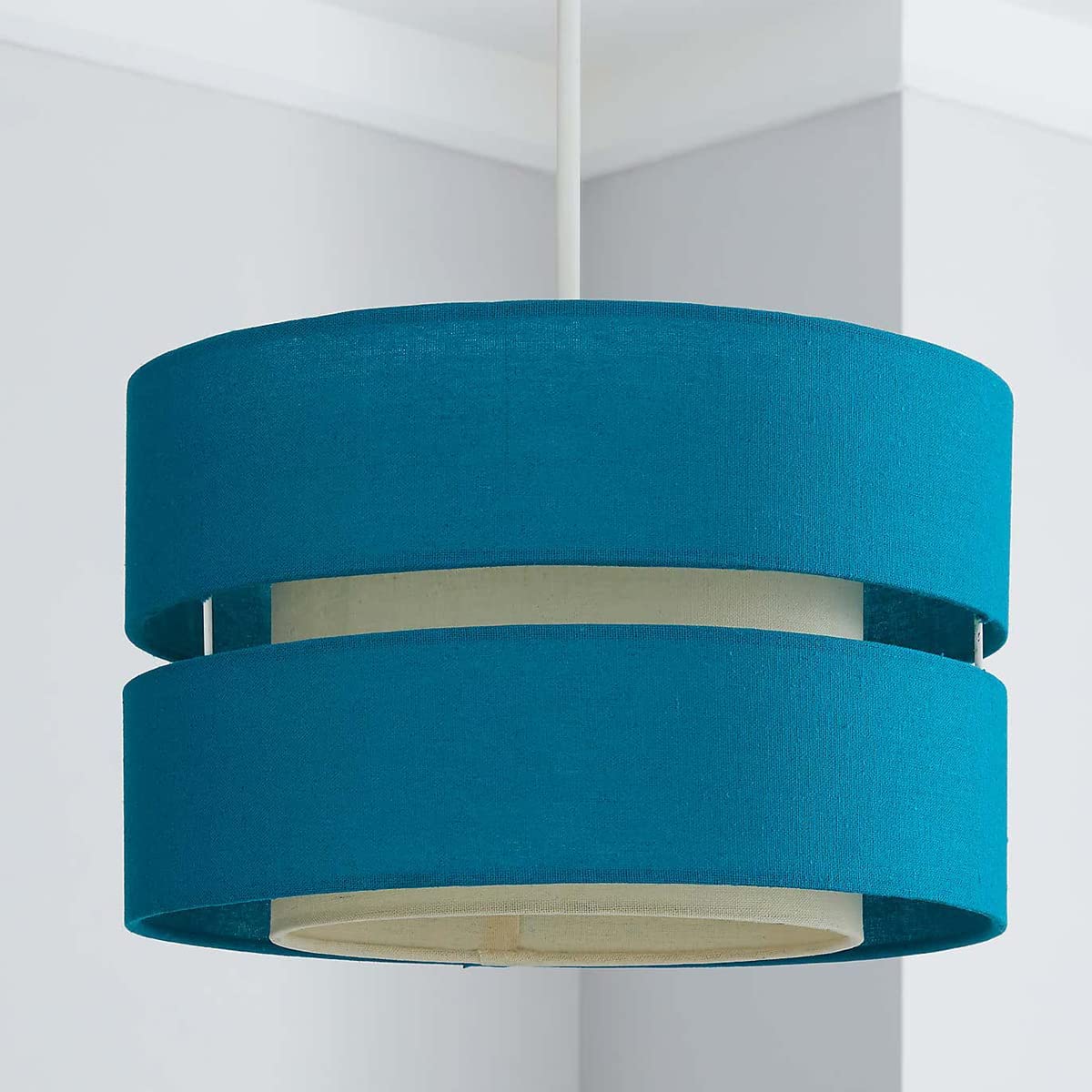 Our Gayle two tiered luxury fabric double layered shade is contemporary in its appearance and we have designed the shade to suit a range of interiors. Easy to fit simply attached to an existing pendant flitting.  It is crafted from high quality fabric material in two layers and complimented with a white inner which looks beautiful when light shines through. The shade has been made to fit both a ceiling light or lamp base.