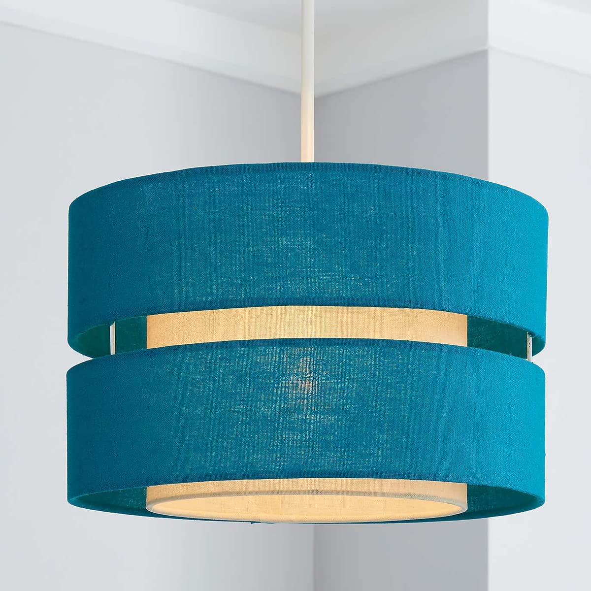 Our Gayle two tiered luxury fabric double layered shade is contemporary in its appearance and we have designed the shade to suit a range of interiors. Easy to fit simply attached to an existing pendant flitting.  It is crafted from high quality fabric material in two layers and complimented with a white inner which looks beautiful when light shines through. The shade has been made to fit both a ceiling light or lamp base.
