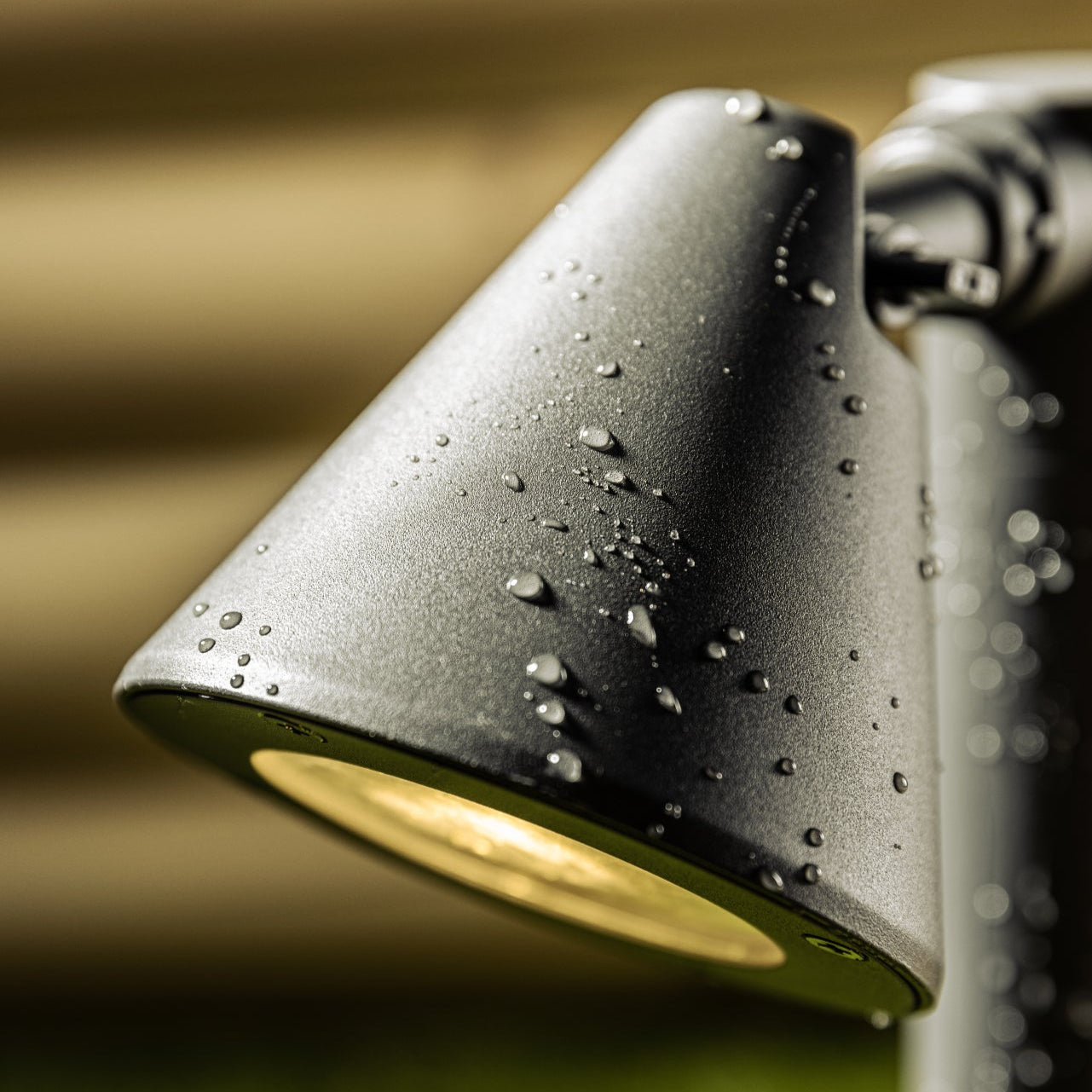 Outdoor light fixture with water droplets on a blurred background