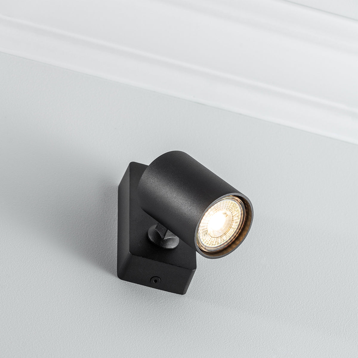 The black Nell lamp consists of a cylindrical spotlight, which can be tilted and adjusted on its own axis. The spotlight is attached to a rectangular bracket, which makes it equally suitable for mounting on walls and ceilings. Made of an aluminium body and powder coated black, the lamp with its simple design fits well into different spaces. Whether functional office or cosy home - the timeless lamp is an perfect for many types of use.