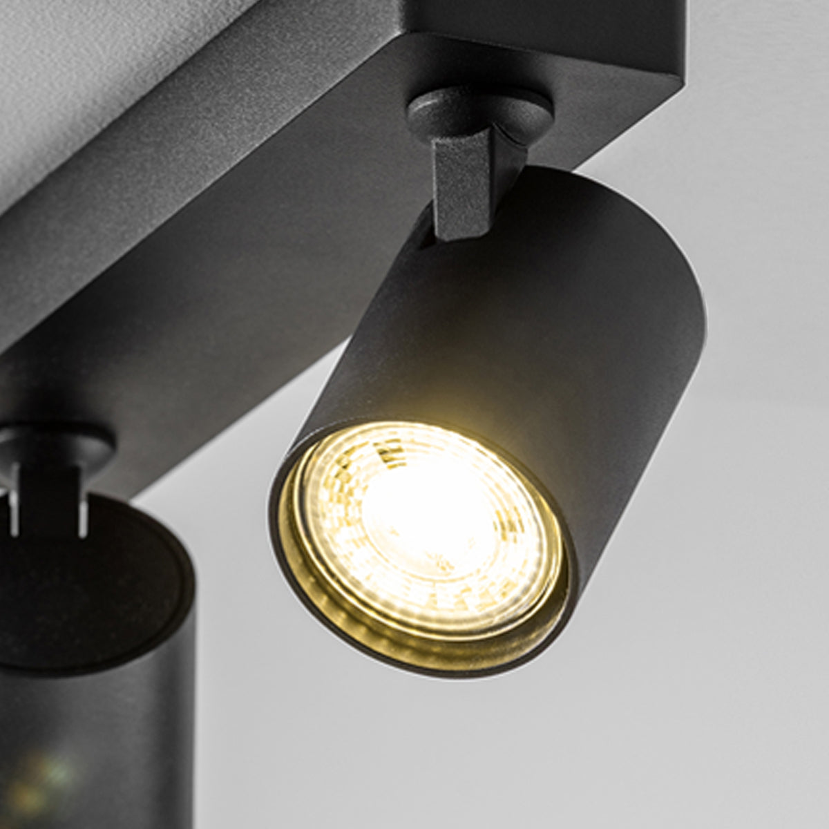 The black Nell twin lamp consists of two cylindrical spotlights, both of which can be tilted and adjusted on their own axis. The spotlights are attached to a rectangular bracket, which makes them equally suitable for mounting on walls and ceilings. Made of an aluminium body and powder coated black, the lamp with its simple design fits well into different spaces.
