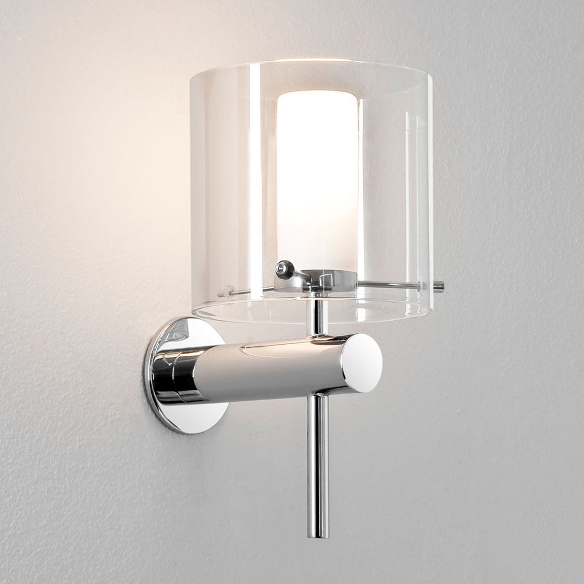 Add a contemporary feature to your interior with this single bulb wall light. The shade is artistically designed in clear glass, for a contemporary take on a classic design. Ceiling rose and fittings are available in an antique brass or a polished chrome finish.