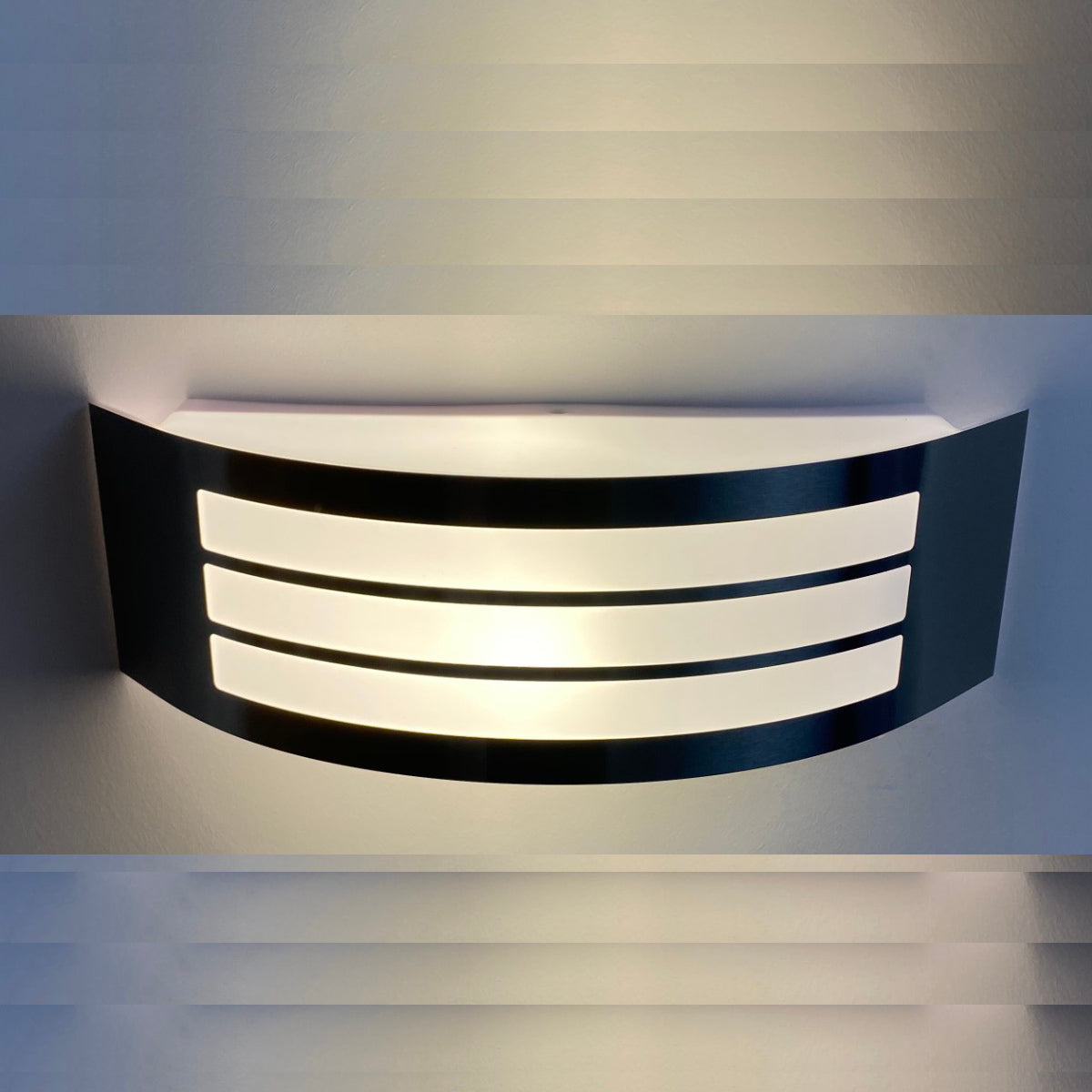 This stylish Striker outdoor light boasts a polycarbonate shade, crafted from stainless steel and adorned with a series of narrow stripes. Its surface disperses the lamp's light uniformly, creating a tranquil, inviting ambiance both indoors and out.