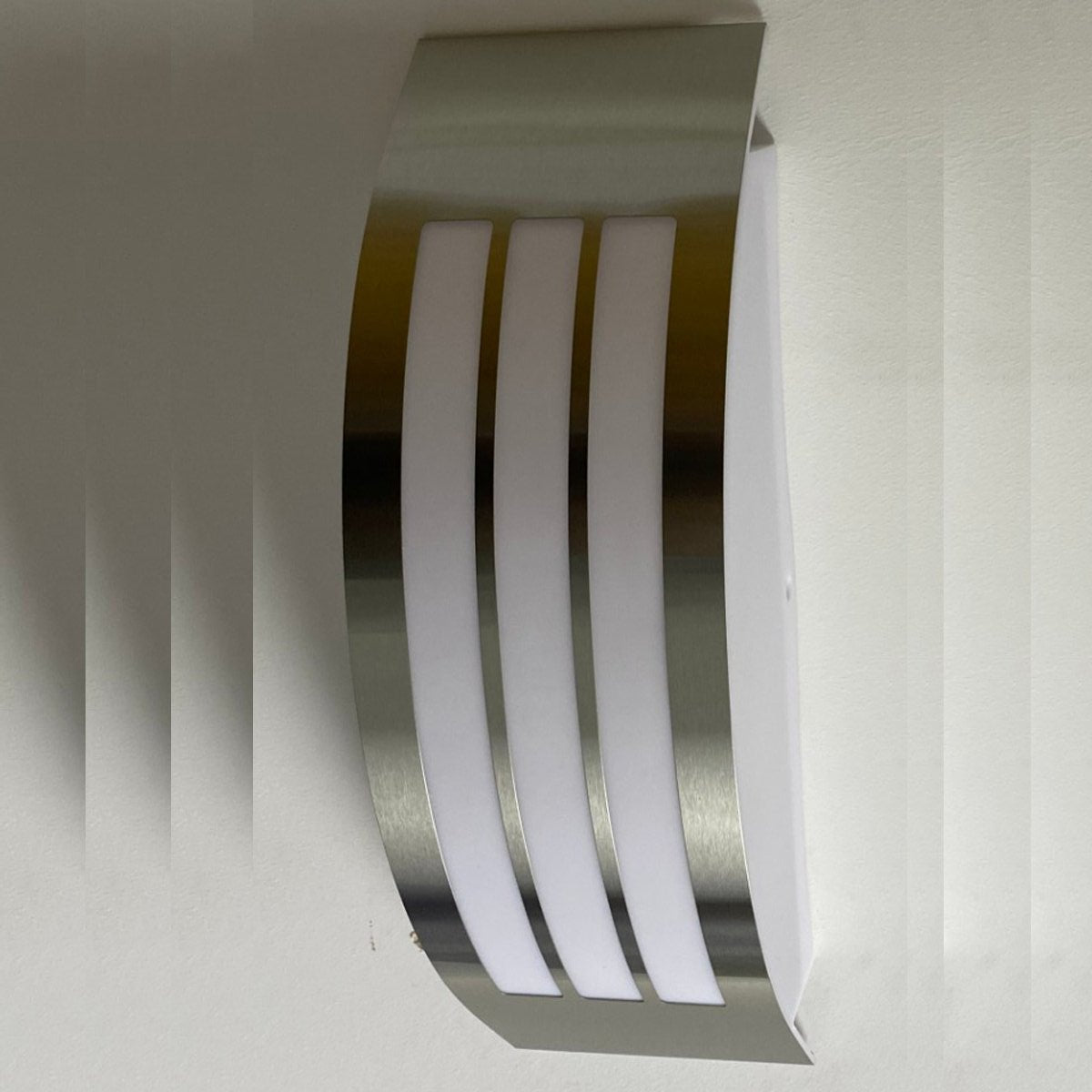 Stylish Striker with a shade made of polycarbonate is a hemispherical outdoor lamp holder, made of stainless steel, decorated with additional, narrower stripes. The surface distributes the light of the lamp softly and evenly, creating an atmospheric, pleasant light even outdoors.