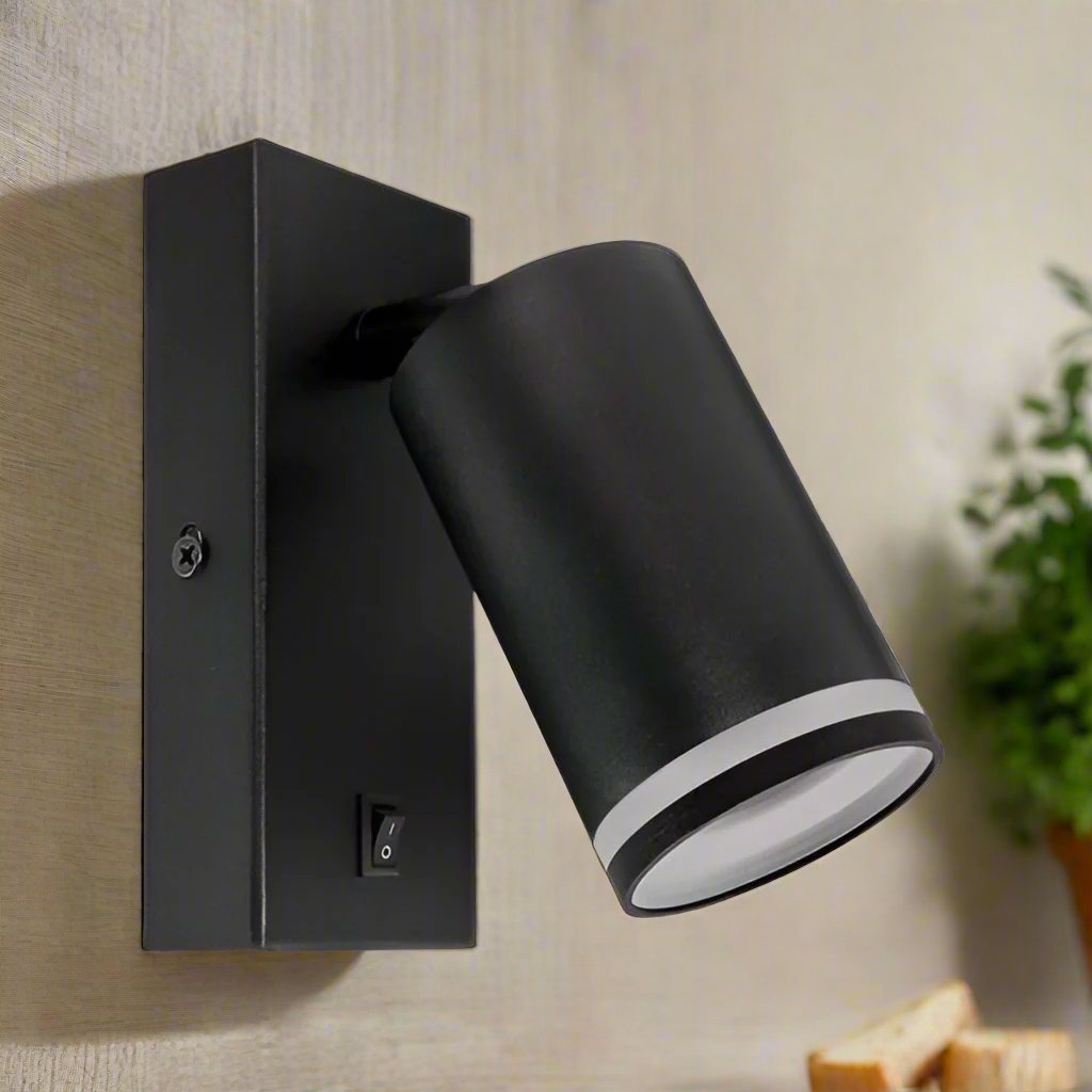 The black Bella lamp consists of a cylindrical spotlight, which can be tilted and adjusted on its own axis. The lamp base has a on/off switch making it ideal for a bedside reading lamp and has a halo reflector. Made of an aluminium body and powder coated black, the lamp with its simple design fits well into different spaces. Whether functional office or cosy home - the timeless lamp is an perfect for many types of use.