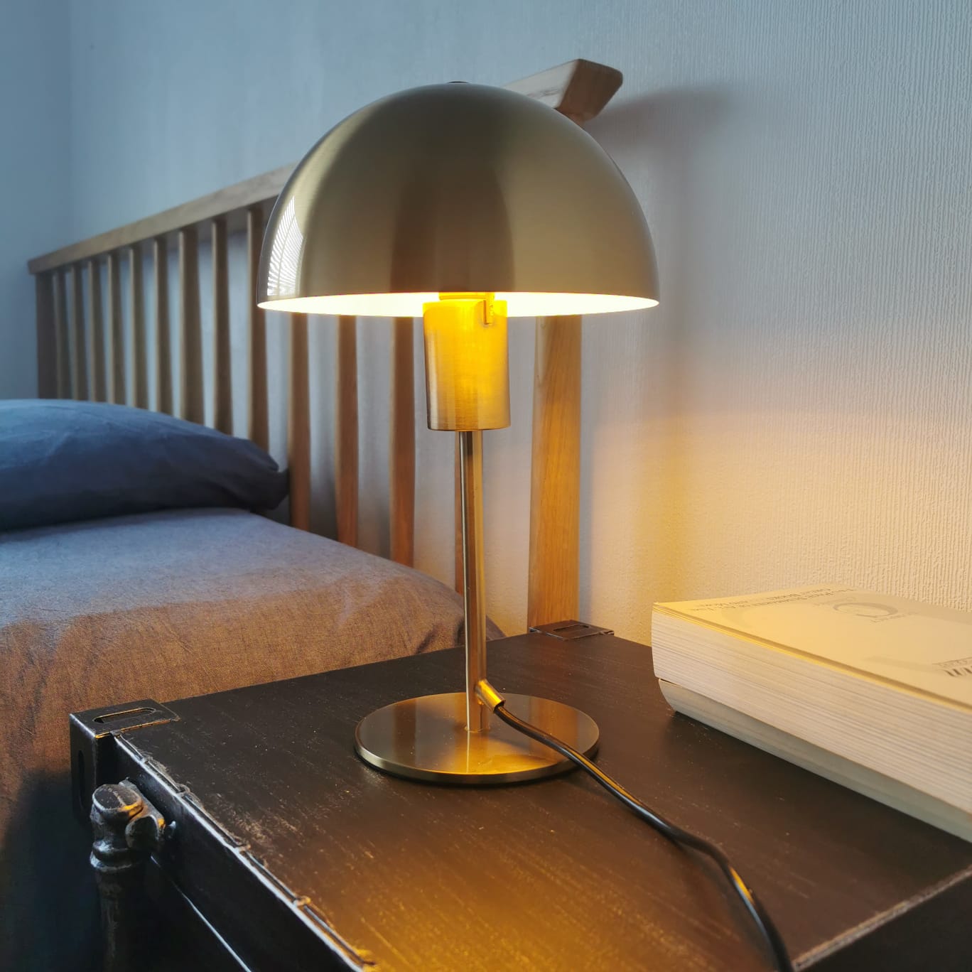 Our Kelly table lamp is a strong visual addition to your space with its distinctive dome-shaped shade and metal frame. Thanks to its brushed gold brass metal finish, it will suit both modern and Mid-Century inspired settings. Light reflects off the shade to enhance a warm and inviting glow.